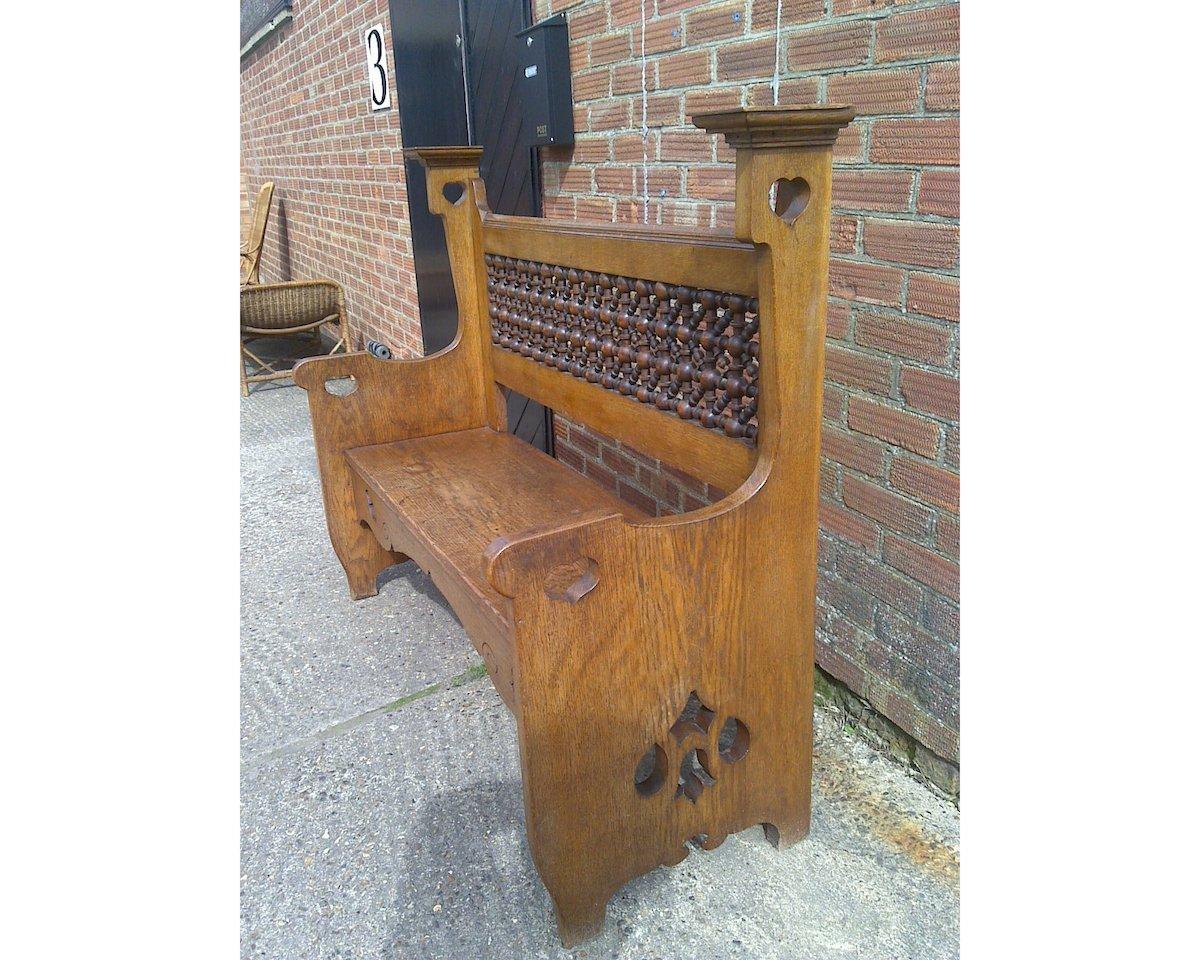Arts and Crafts An Arts & Crafts Oak Settle by Liberty & Co with Mashrabiya turnings to the back For Sale