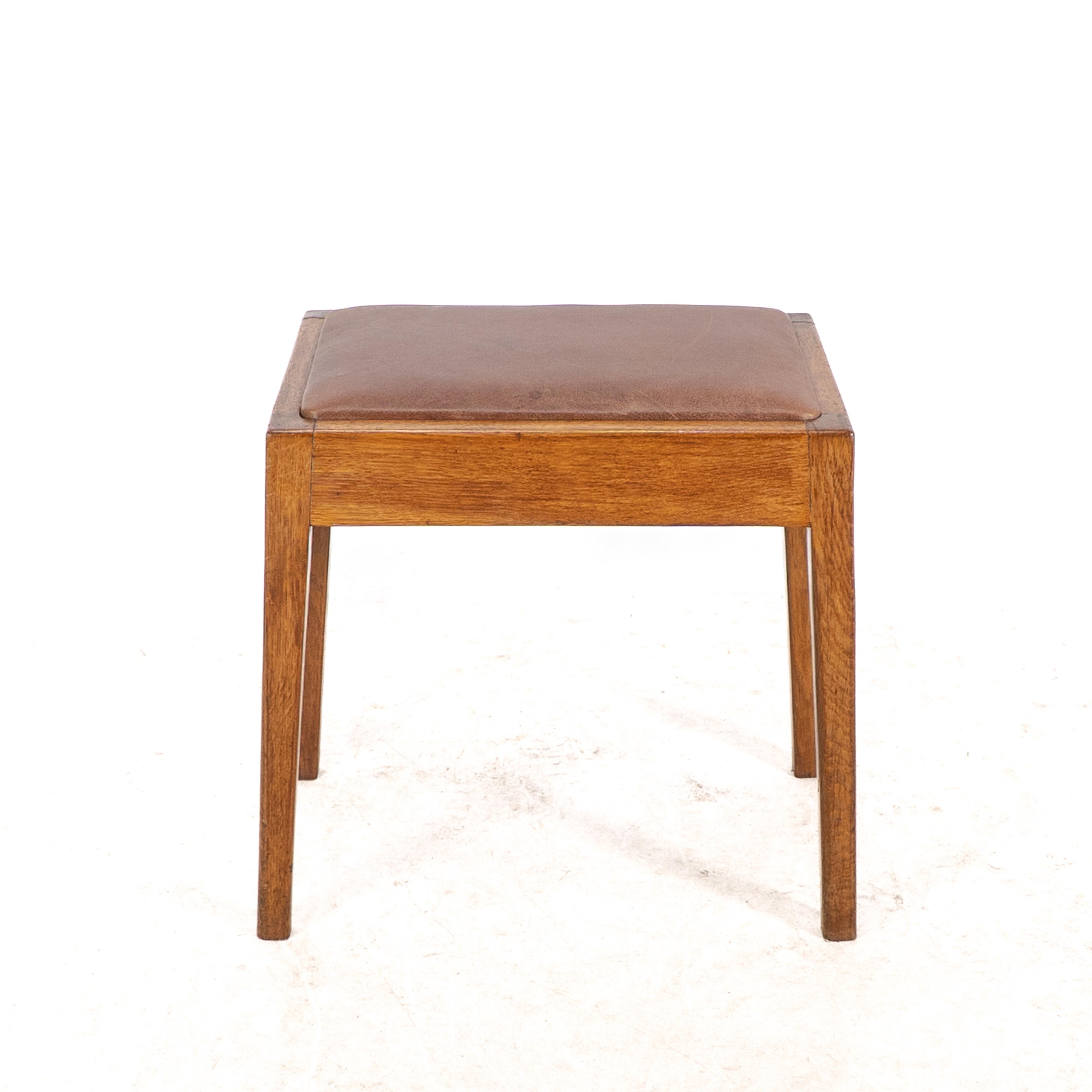 Un taburete Arts and Crafts de roble con asiento profesional de cuero retapizado