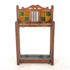 An Arts & Crafts oak umbrella & stick stand with original green & mustard tiles