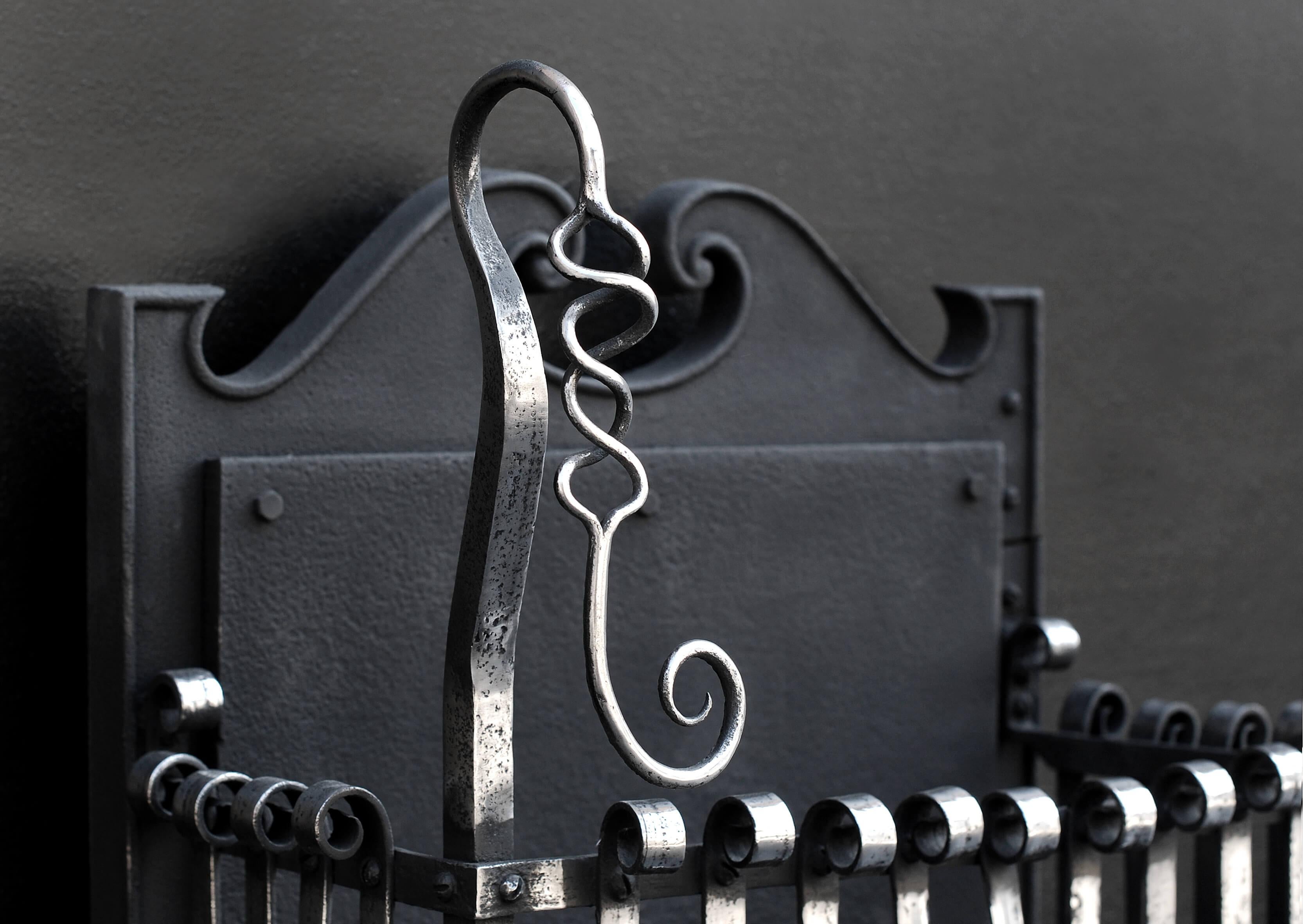 A mid/late 19th century English Arts and Crafts polished wrought iron firegrate. The burning area with polished scrolls surmounted by decorative intertwined wrought iron adornments. Shaped cast iron back.

Width At Front:	645 mm      	25 ⅜