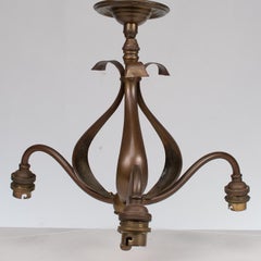 An Arts & Crafts three branch brass ceiling light with stylized leaf detail