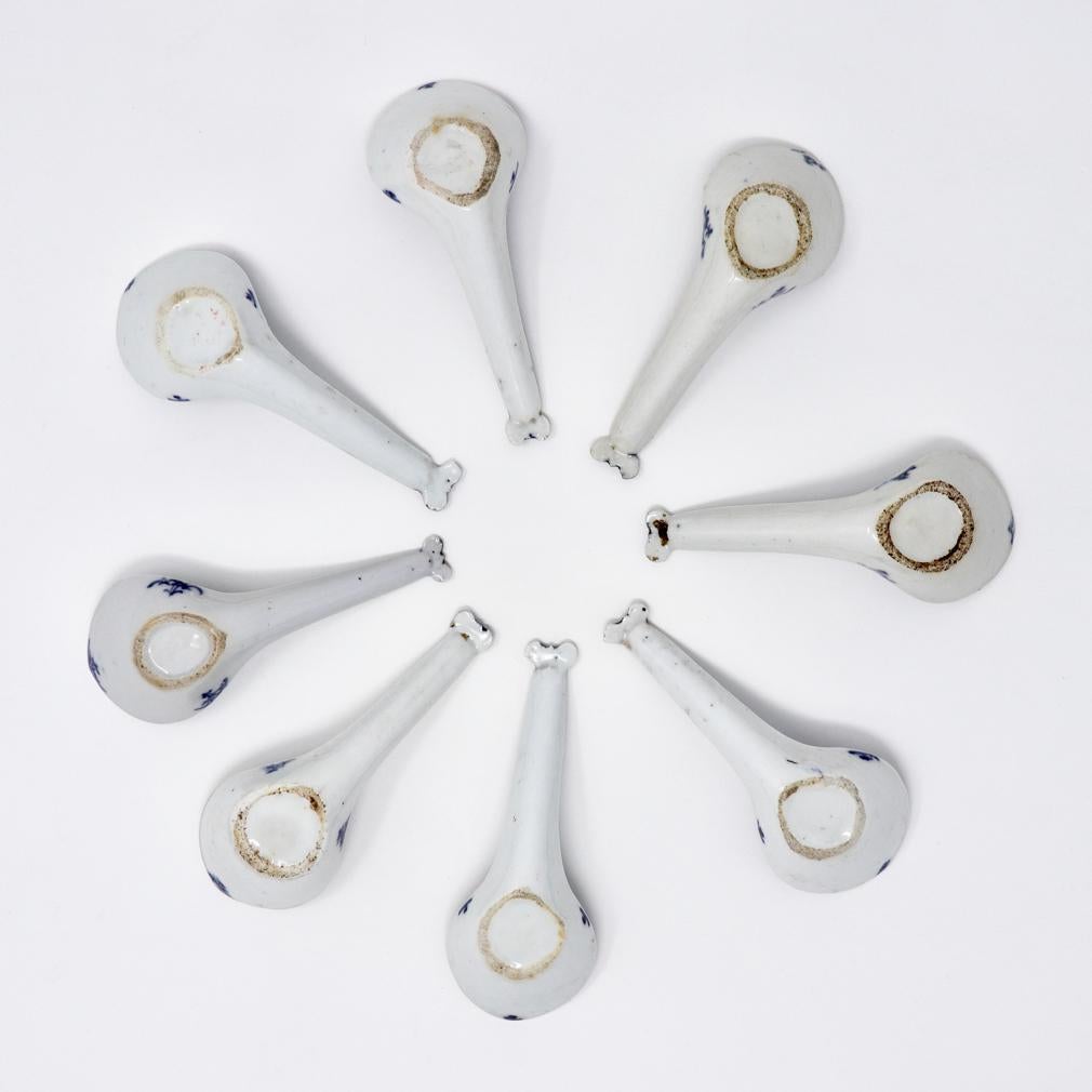 An assembled collection of 8 blue and white Chinese porcelain spoons.
Each spoon  modeled with a generous well, unglazed foot ring and a decorative element of a handle end in the shape of a butterfly. Each spoon decorated in under glaze cobalt blue