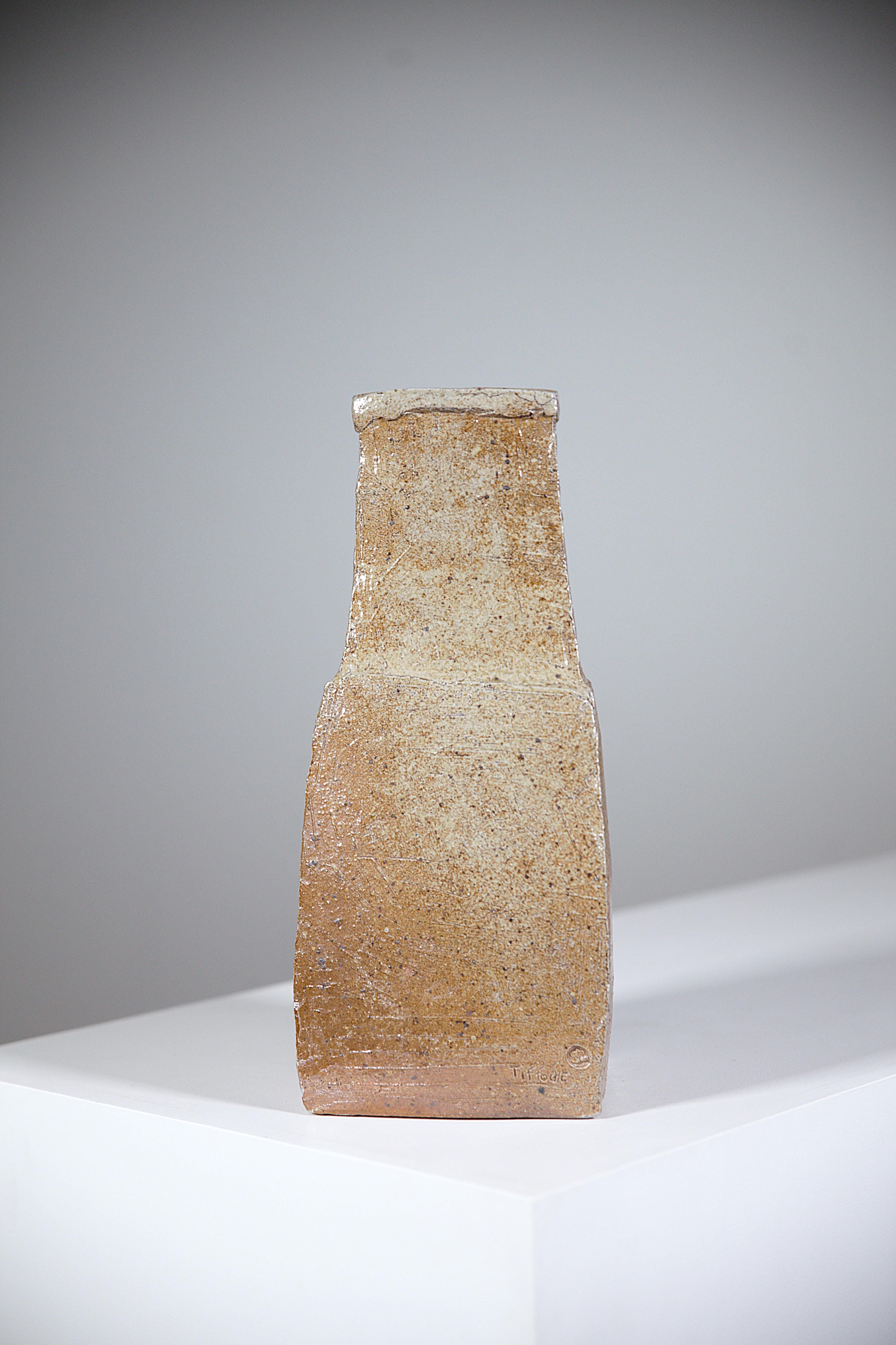 An Asymetric Stoneware Vase by Gustave Tiffoche France 1970's

Different firing colors on all four sides of the vase, beautiful shades of beige and brown

Signed and stamped on the base.

Good condition.