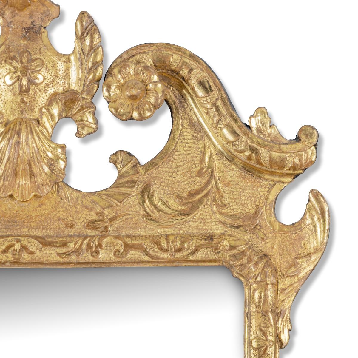 An attractive late George I giltwood mirror, the rectangular frame enclosing a bevelled plate and surmounted by a broken S-scroll pediment, centred on a cartouche, with acanthus leaves on the corners, decorated with further leaves and scrolls on a