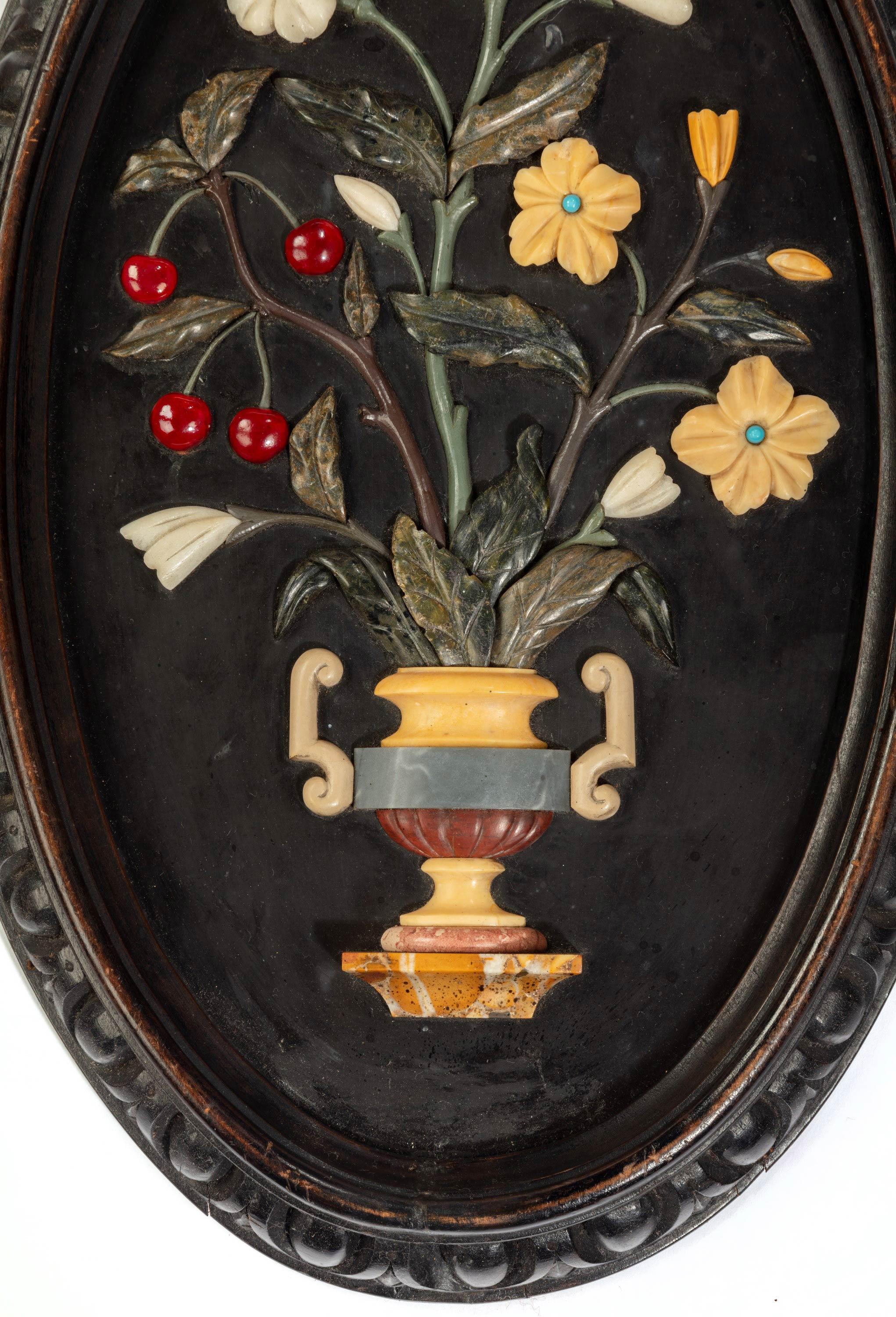 A most attractive pair of late 19th century oval Pietra Dura pictures of flowers in a formalized vase. Beautifully carved.
  