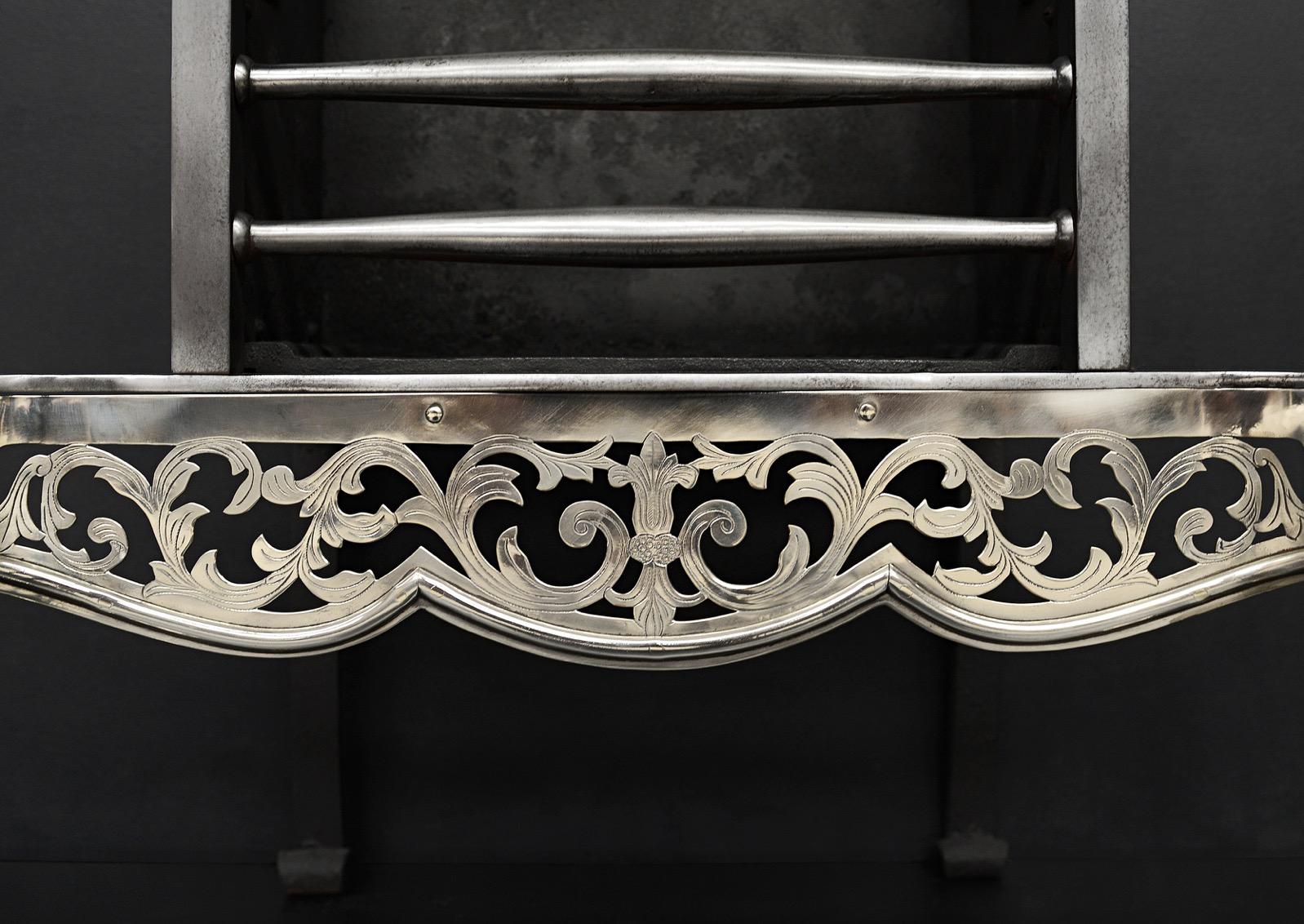 An attractive steel and nickel firegrate, in the mid Georgian style, the pierced and engraved fretwork of floral pattern, tapering column legs with bulbous urn finials. The fretwork, legs, and finials in nickel with polished steel front bars and