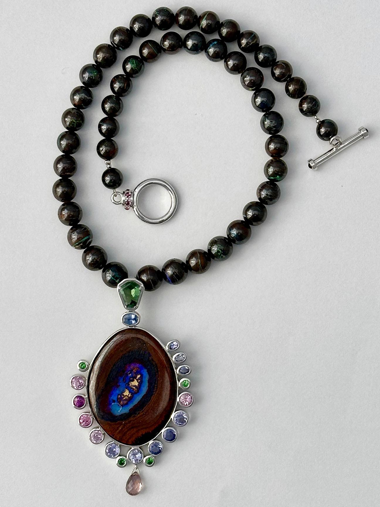 This Majestic one of a kind piece is a masterpiece of color harmony and appeal. A beaded Australian Boulder Opal necklace that features a large central Australian Boulder Opal pendant that is surrounded by Tourmaline, Tanzanites, Tsavorite Garnets