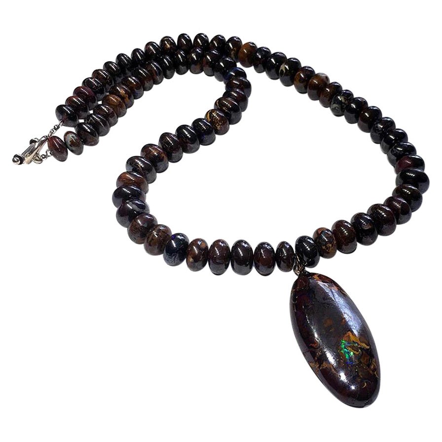 An Australian Boulder Opal Pendant & Opal Beaded Necklace With a Silver Clasp.
This Australian Boulder Opal Jewel consists of 150 Carats of spherical Boulder Opal beads with a colorful central Opal Pendant. The Necklace is 16 Inches long fastened