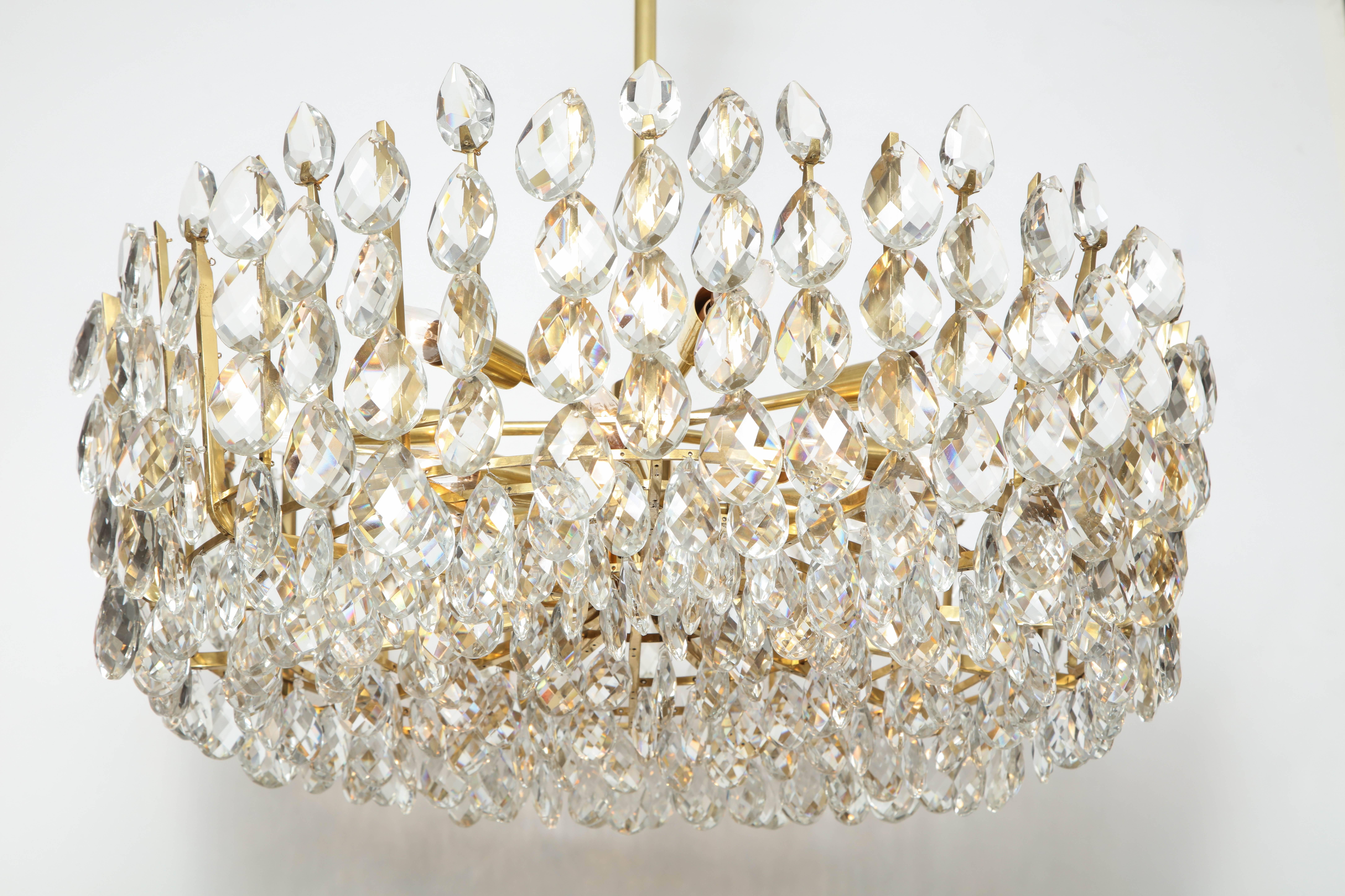 This Austrian crystal chandelier is composed of a brass frame of five concentric circles, and hundreds of pear shaped crystals of varying sizes. This piece will add star quality to any room! It has been rewired for use in the U.S.