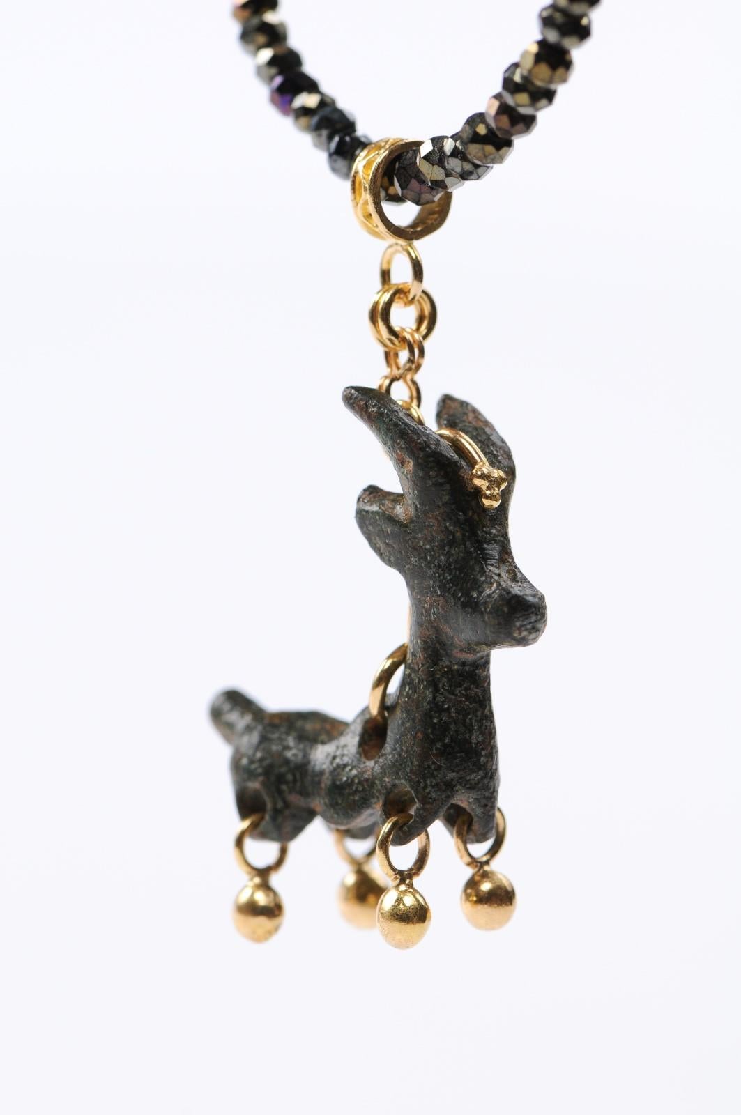 An authentic Roman bronze deer artifact (circa 1st-3rd century AD), with the contemporary addition of the 21-karat gold bezel. This ancient deer in bronze has been artisan crafted into this unique pendant with a custom 21-karat gold attachments at