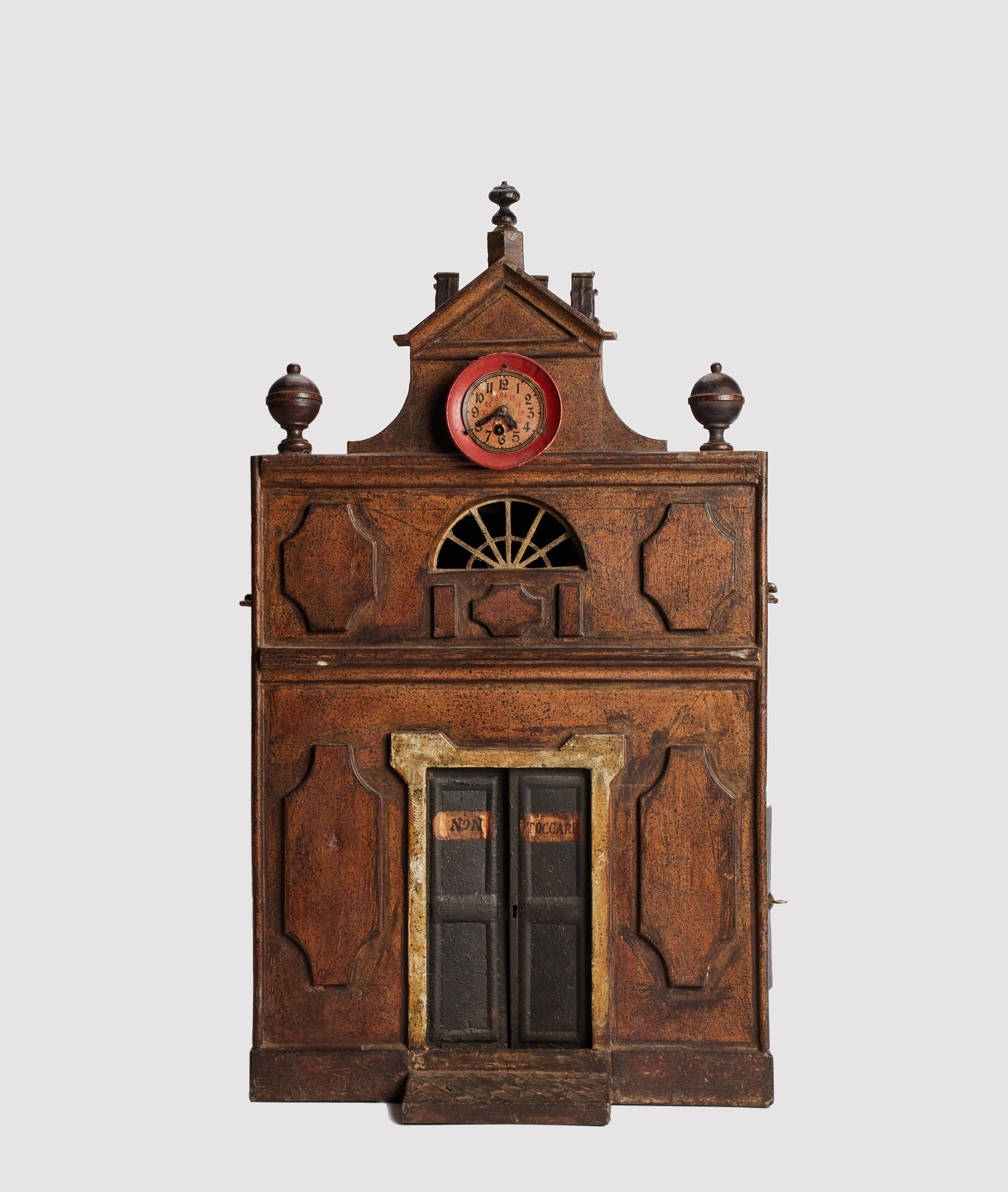 L'automate a la forme d'une maison. La partie avant présente une horloge, une fenêtre semi-circulaire en guise de porte. Le conduit supérieur de la cheminée est l'endroit où l'on dépose le poids en forme de pièce de monnaie. Un mécanisme interne