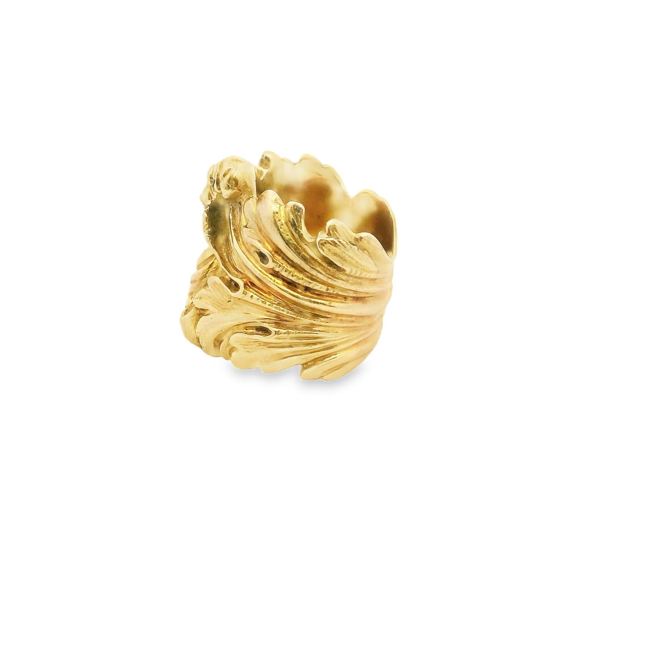 Cette bague exquise présente un design complexe, avec des volutes ornées et des motifs de feuilles. L'artisanat détaillé est mis en valeur par le riche éclat de l'or jaune 18k, ajoutant une touche d'opulence à la pièce.

Avec un poids substantiel de