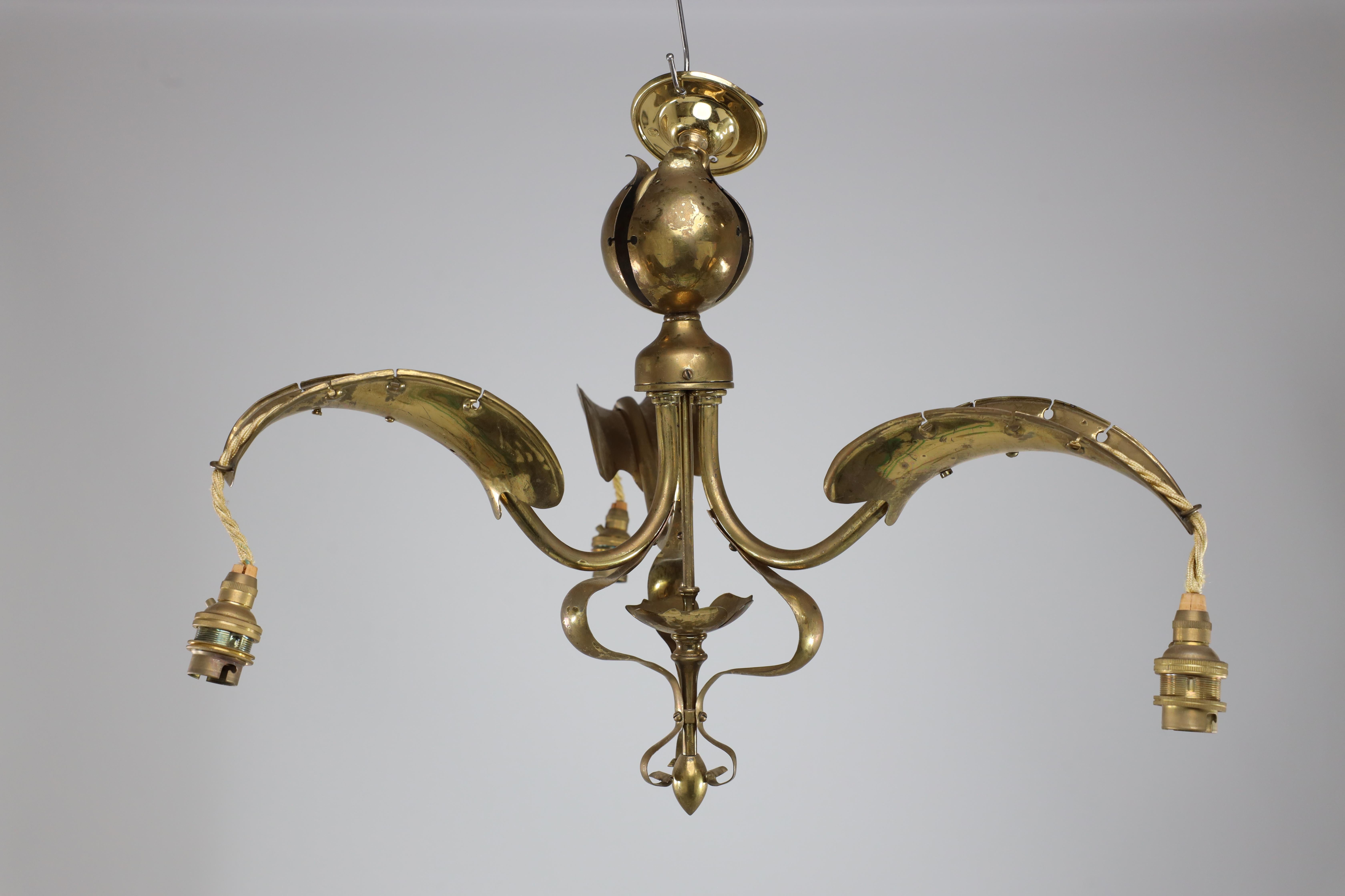 Arts and Crafts A brass three arm ceiling light with a central shaped sphere & leaf decoration For Sale