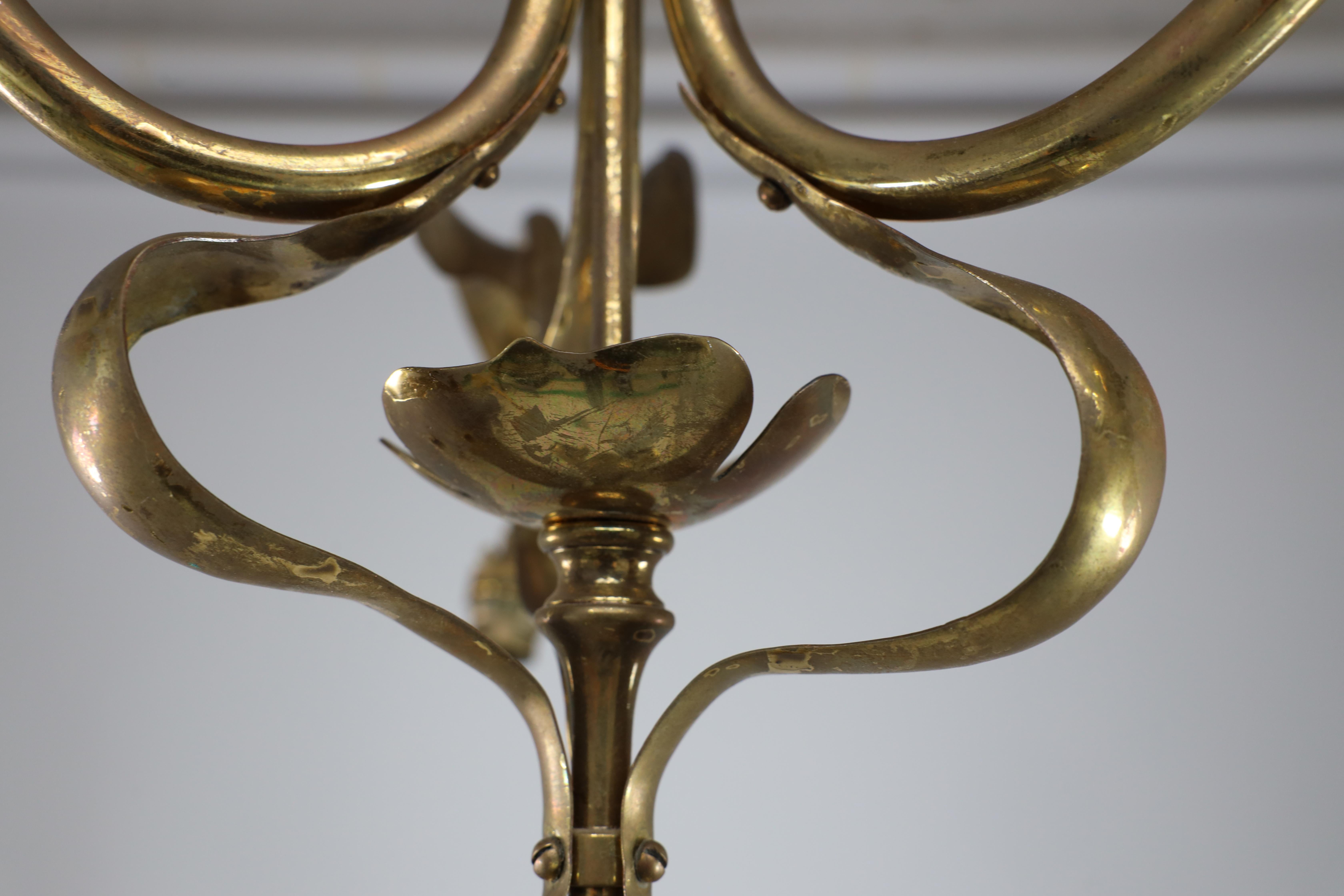 Brass A brass three arm ceiling light with a central shaped sphere & leaf decoration For Sale