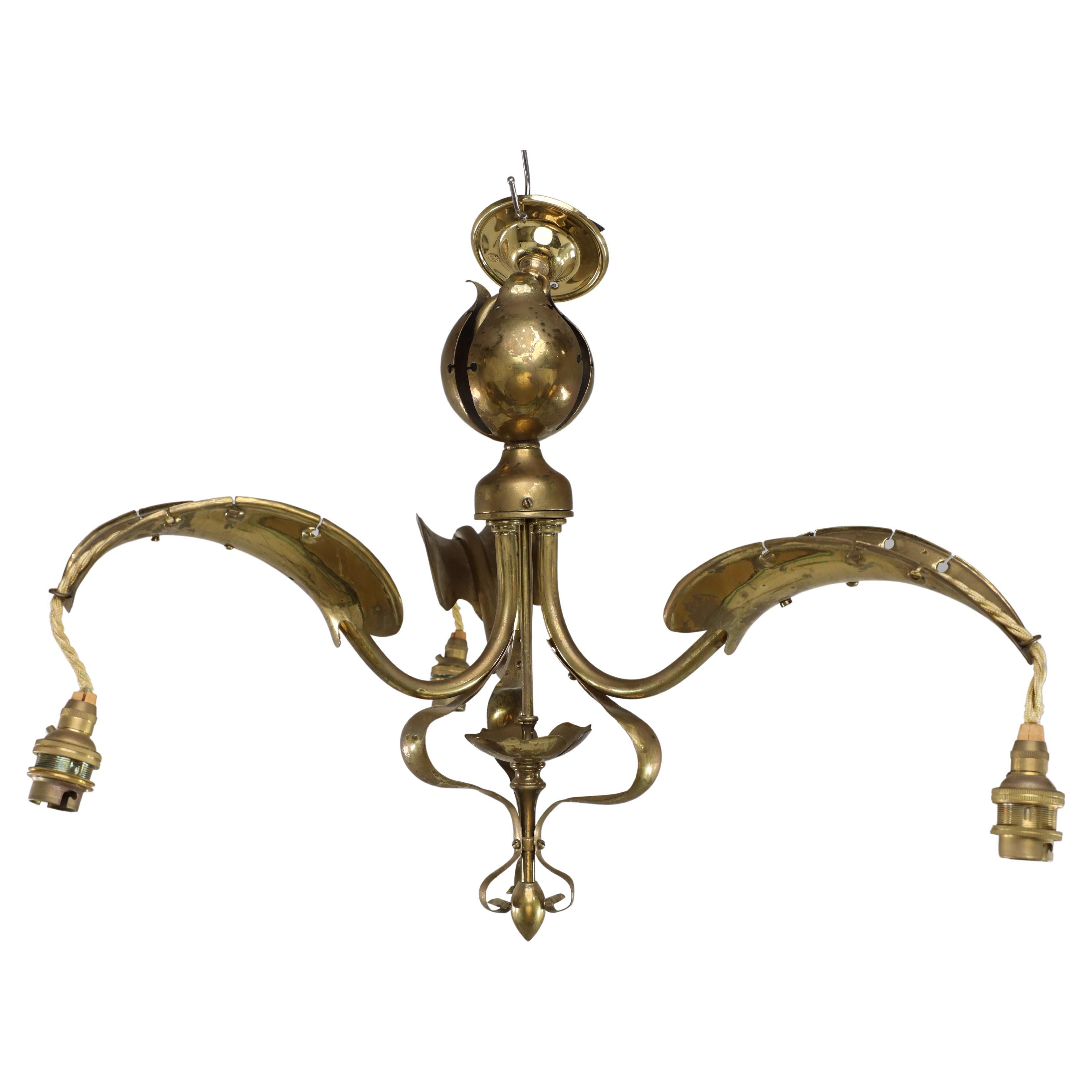 A brass three arm ceiling light with a central shaped sphere & leaf decoration For Sale