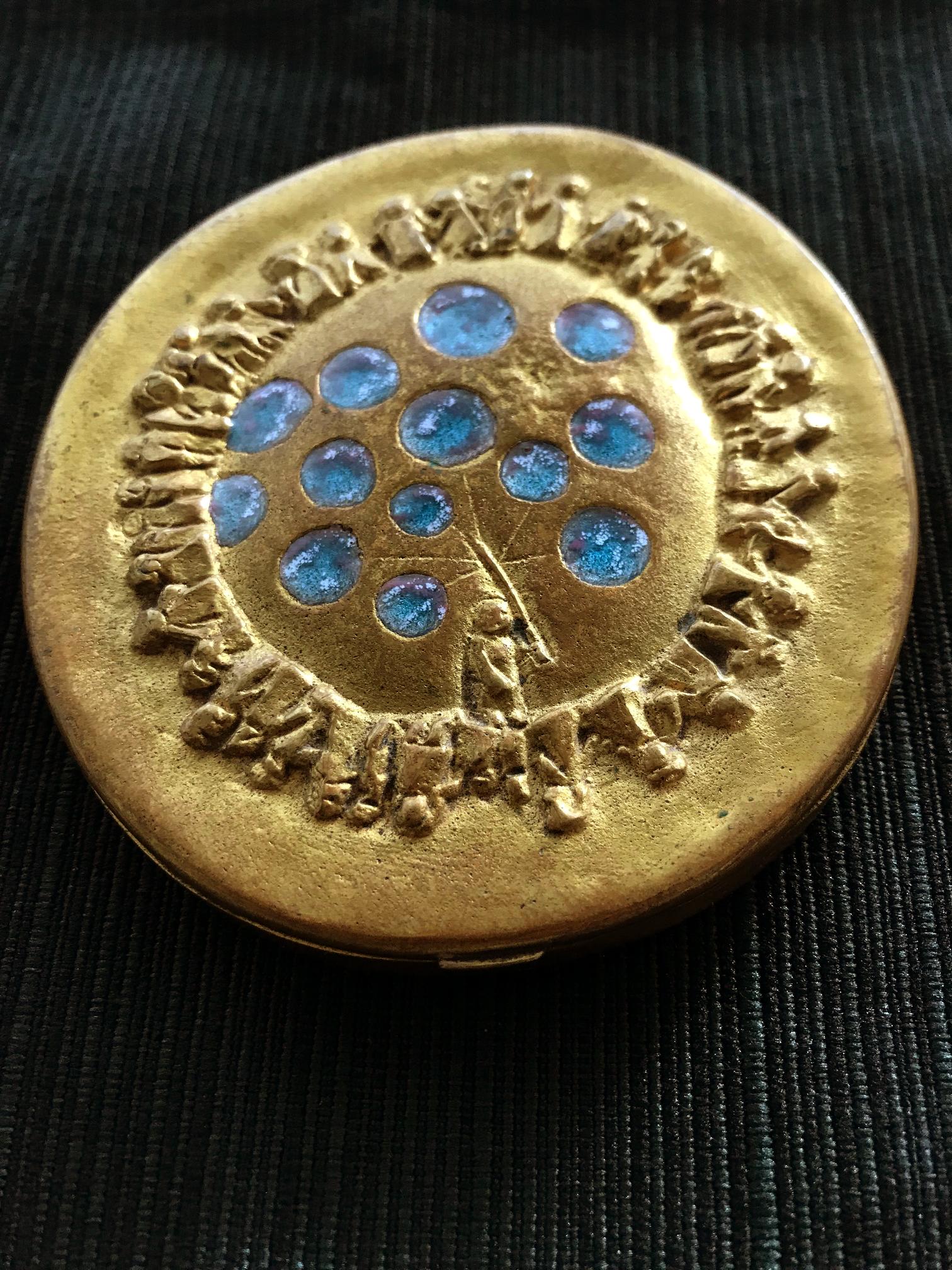 A circular bronze compact box (poudrier) entitled 