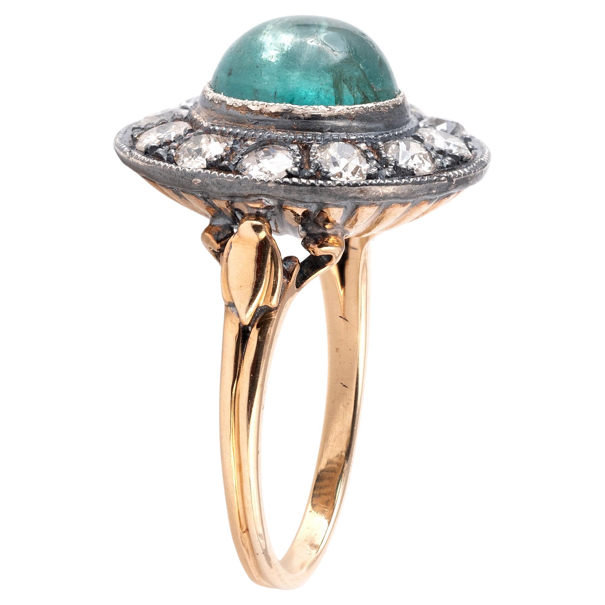 Collet-set to the centre with an oval cabochon emerald weighing approximately 2ct, framed by rows of single-cut and round old cut diamonds, estimated total diamond weight approximately 1.00ct.
Setting in silver and gold.
Top size 18mm
Size 6
Weight: