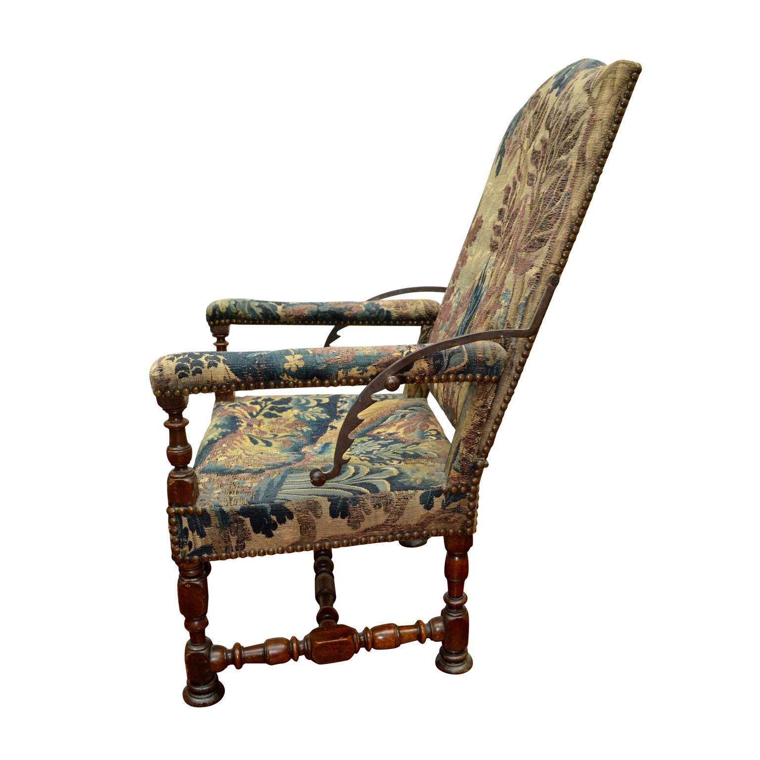 A rare late 17th century French reclining armchair with a carved walnut stretcher, upholstered in its original verdure tapestry of the period. This is a 400 year old precursor to the La-Z-Boy brand and belongs in a Furniture Museum. As can be seen