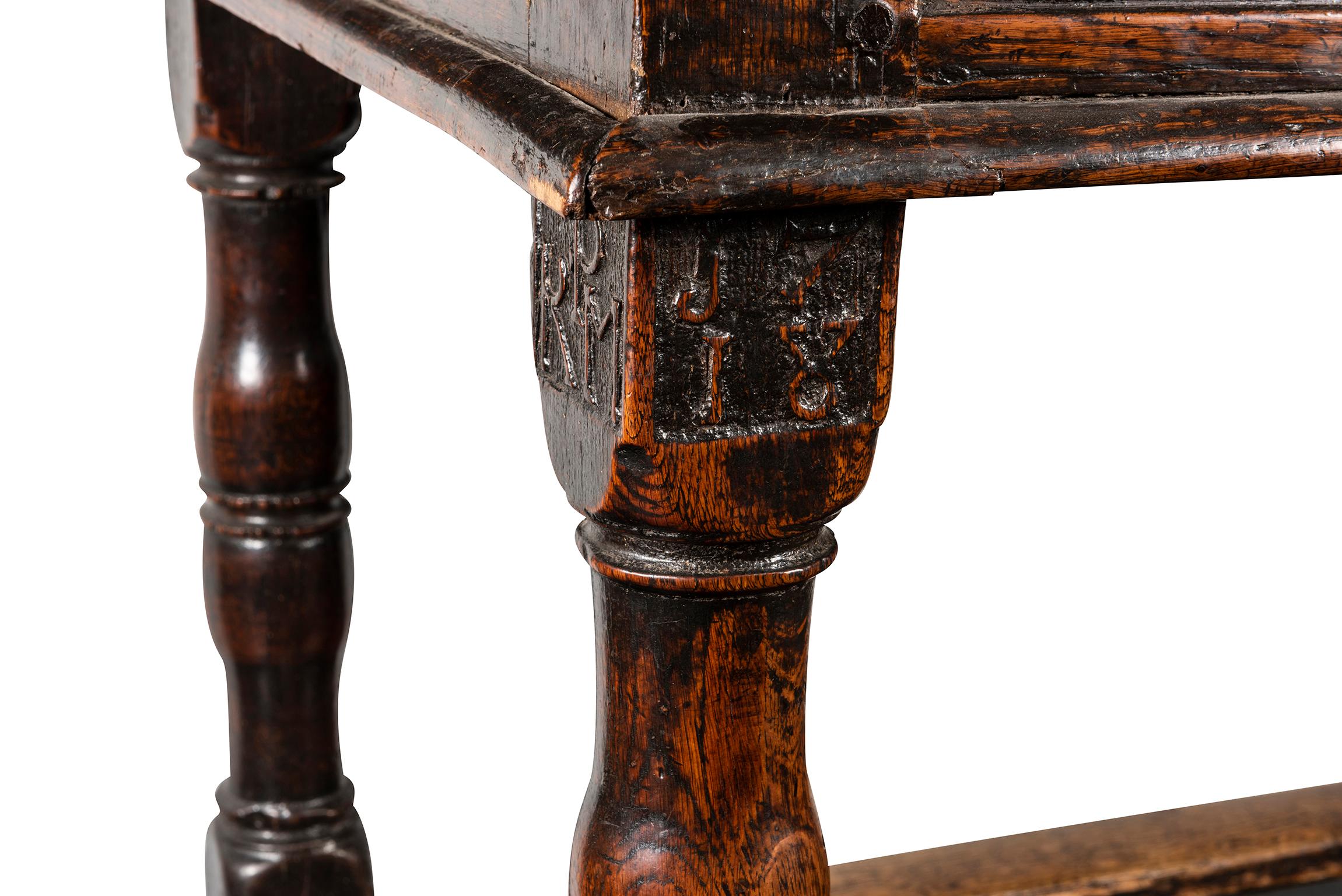 The plank top with butt ends over a recessed blank frieze supported by four turned legs and united by chamfered horizontal stretchers, carving to the capital of one leg 'RPM' and 'J718' dating the table to 1718.

Provenance: Mentmore Castle,