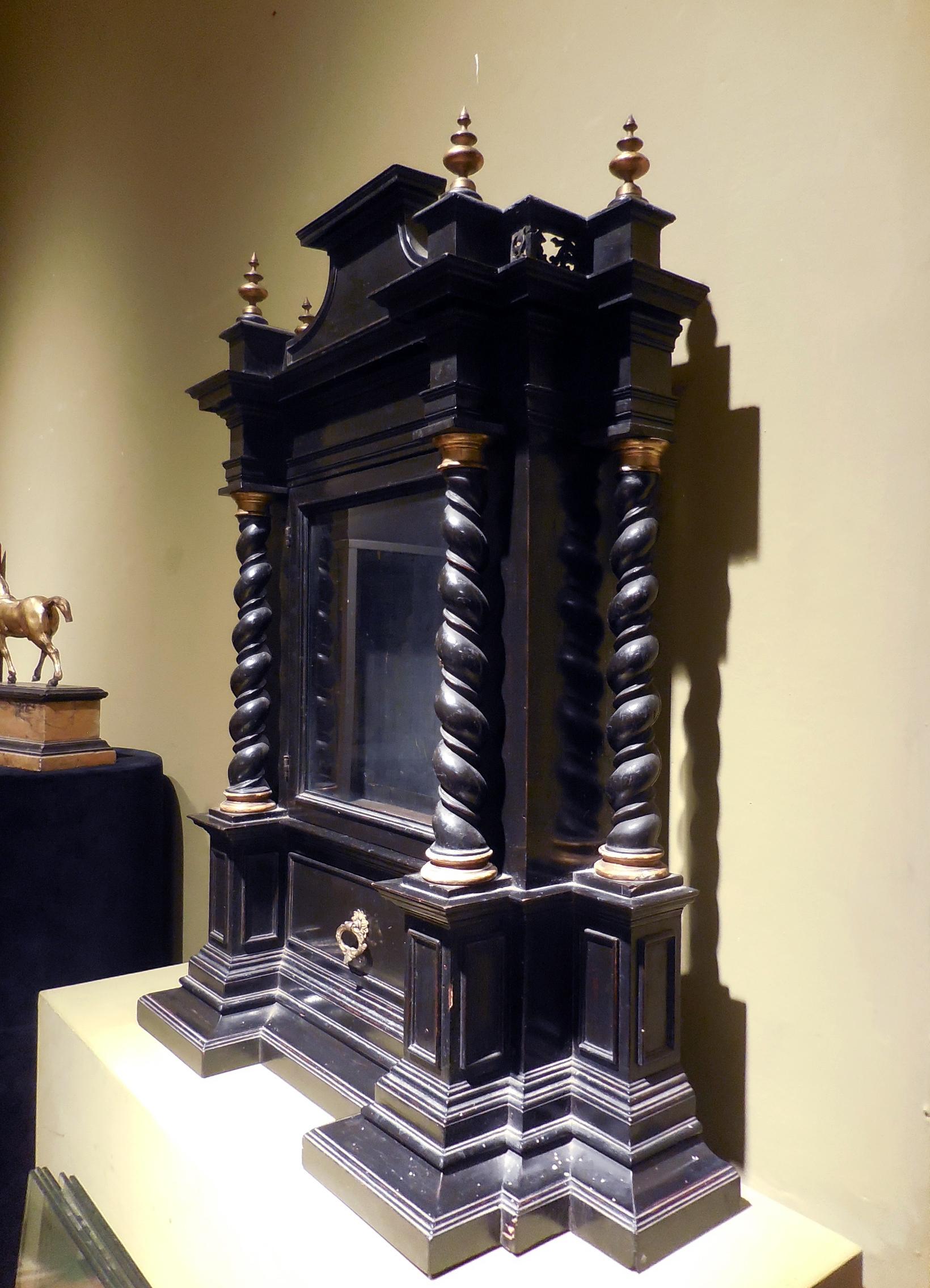 An early 18th century Florentine ebonized wood aedicule case with gilt metal embellishments

Ambit of Leonard van der Vinne
Possibly first decade of the 18th century; Florence, Italy
Approximate size: 83.5 (h) x 69 (w) x 23 (d) cm

The cabinet’s