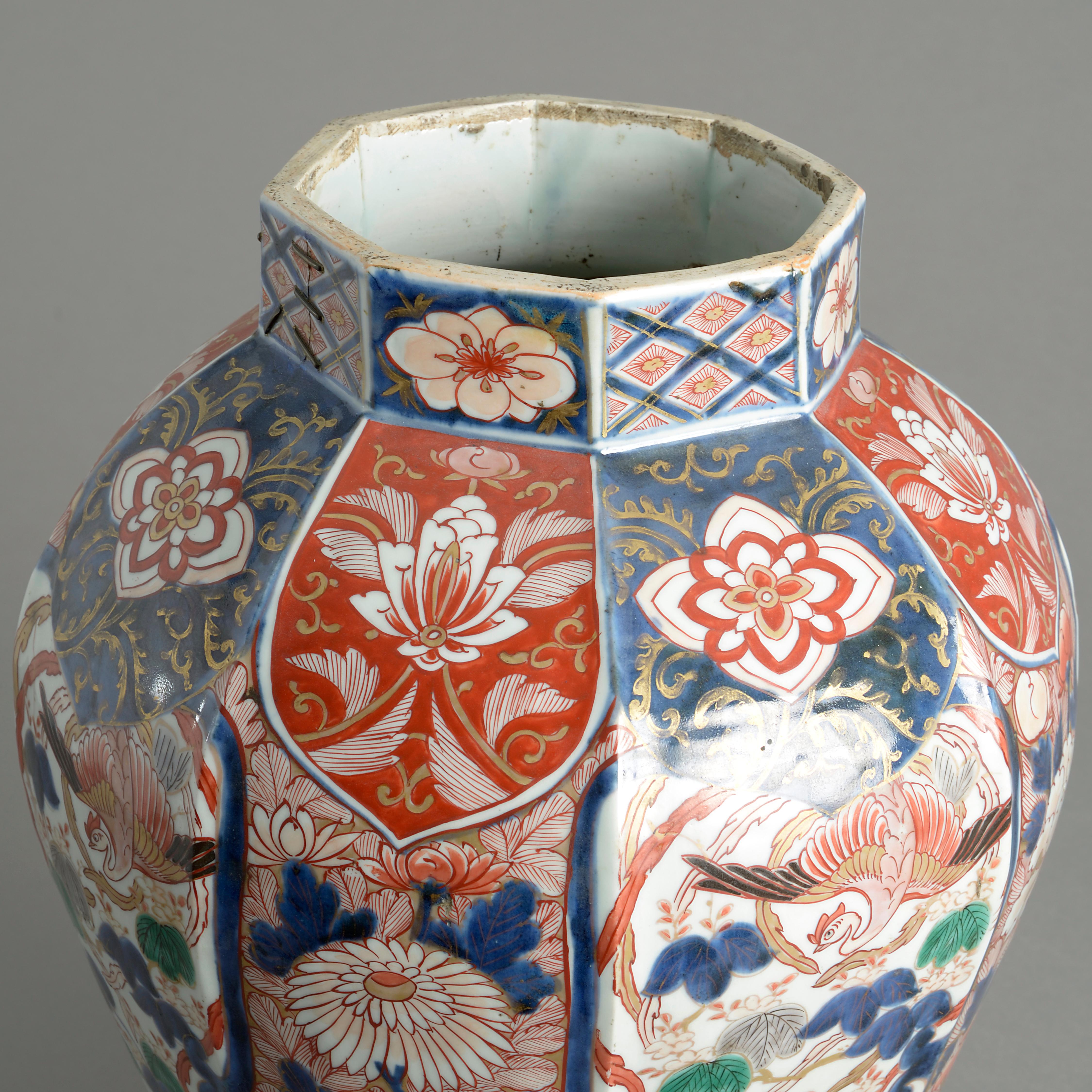 An early 18th century Imari porcelain vase, of faceted baluster form, decorated throughout with foliage, flowers and fantastical birds in the traditional manner with red, blue and green glazes upon a white ground with gilded highlights.