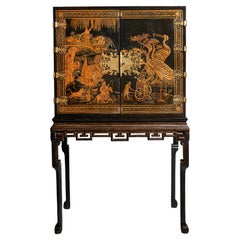 An early 18th century Queen Anne japanned chinoiserie cabinet on stand.