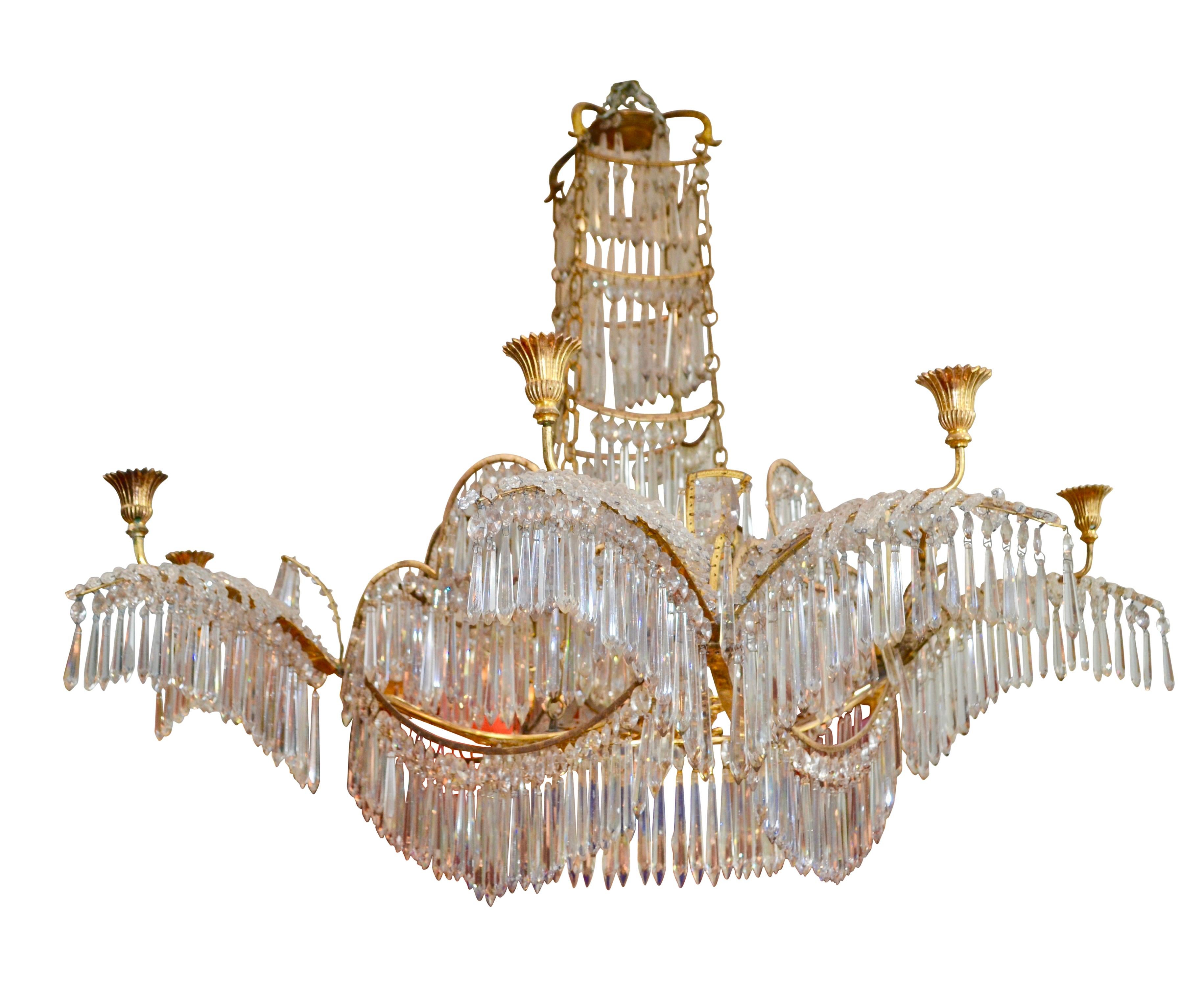 An early 19th century Russian chandelier having eight candle arms. The design is intended to represent waterfalls. The central stem of the chandelier is in four tiers each hung with original long cut crystals and almond shaped drops. The central