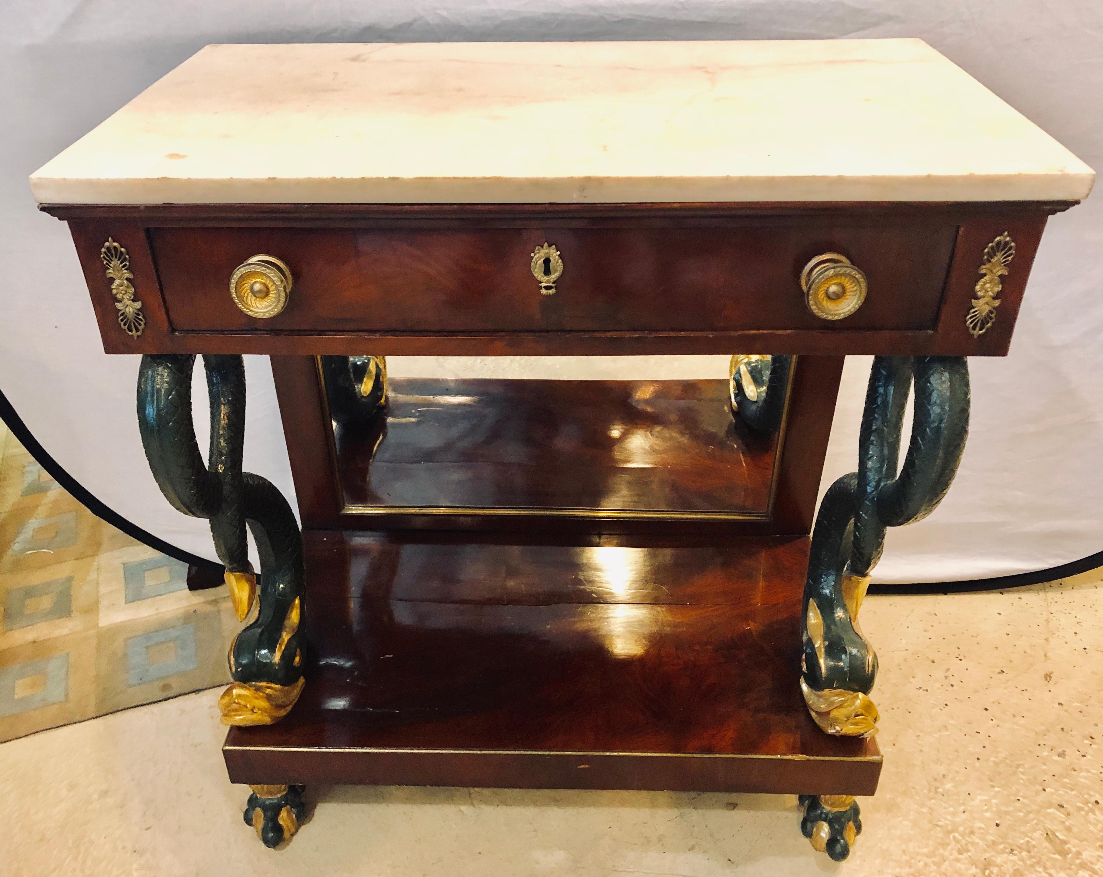 Mesa de muelle o consola de principios del siglo XIX, de estilo Imperio, pintada con pintura de serpiente y decorada con dorados. La encimera de mármol blanco se apoya en un único cajón con tiradores de bronce flanqueado por esquinas decorativas de