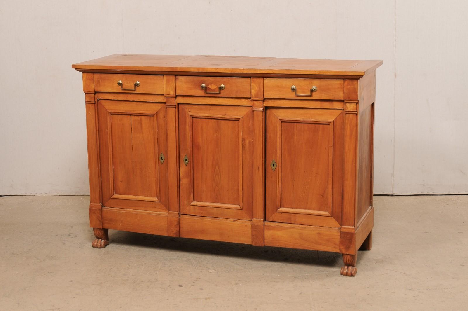 A French wooden credenza on paw feet from the early 19th century. This antique buffet from France has a rectangular-shaped top with slightly overhangs the case below, which house three dovetailed drawers adorn with brass rectangular-pull hardware,