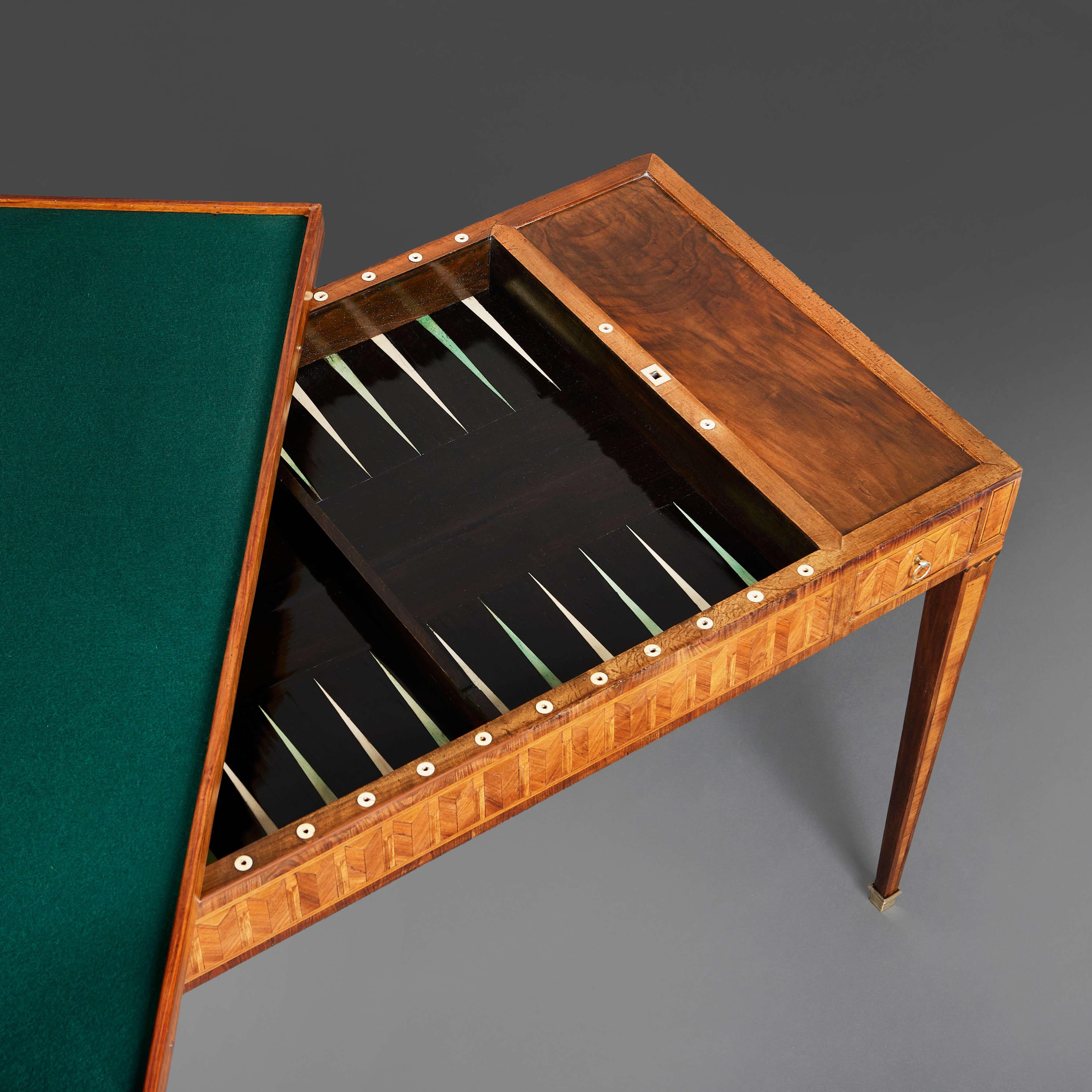 Eccezionale tavolo da gioco tric trac dei primi dell'Ottocento, con un insolito piano intarsiato decorato con volute di fiori e uccelli contrapposti su ciascun lato, il retro del piano rivestito in baize verde per le carte, che si apre per rivelare
