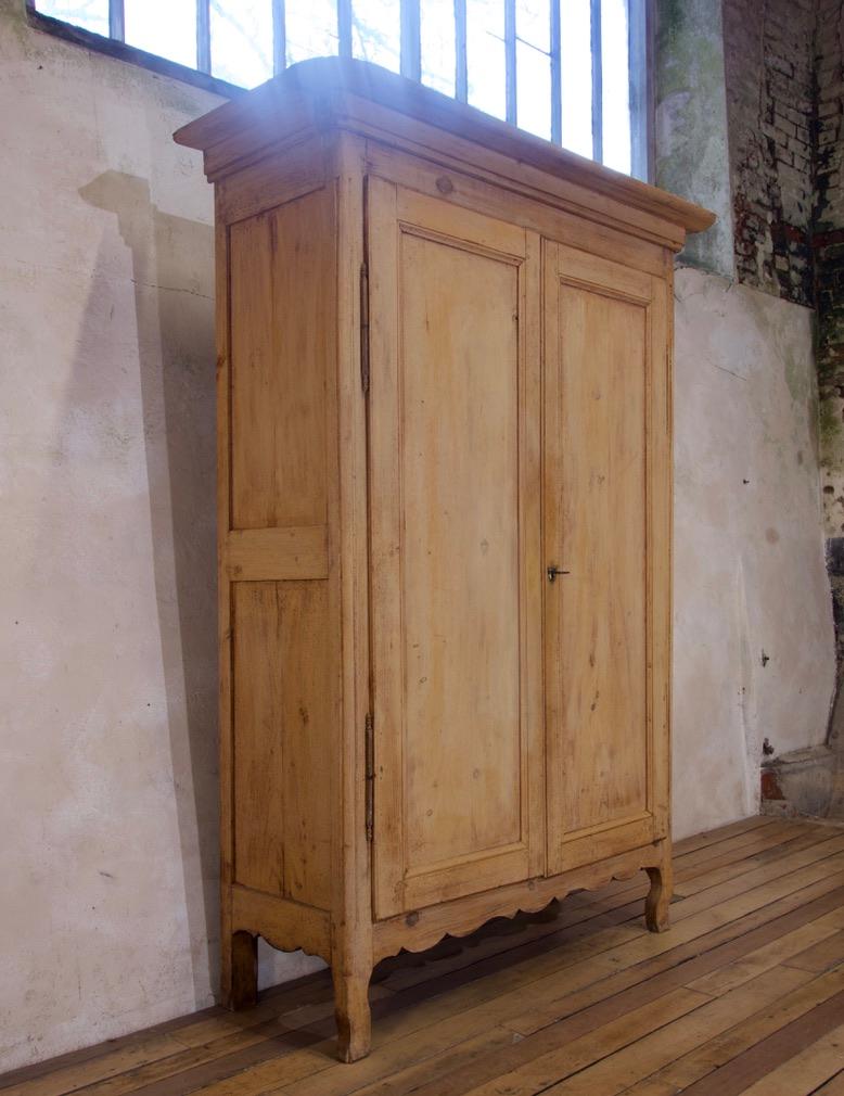 An elegant 19th century French Provincial armoire. Displaying a pair of panelled doors, enclosing three shelves - one of which houses a pair of drawers. Raised on short cabriolet legs, united by a simplistic shaped apron. 

This armoire retains