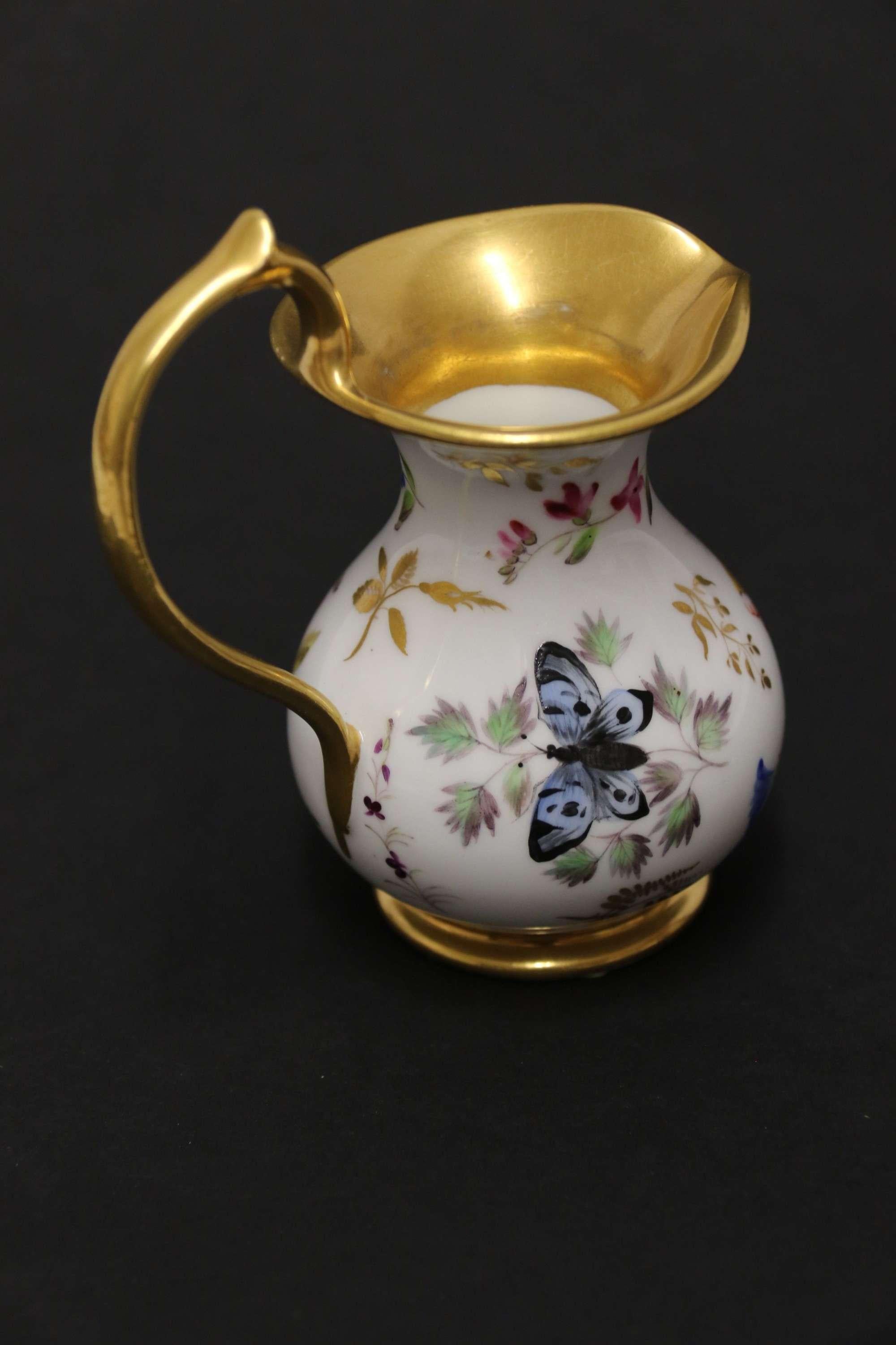 A Fine Quality Early 19th Century French Porcelain Miniature Ewer

A splendid small French porcelain ewer, circa 1830 exquisitely hand painted with an assortment of flowers, a shell, beetle, and butterfly. The rim, foot and fine handle are richly