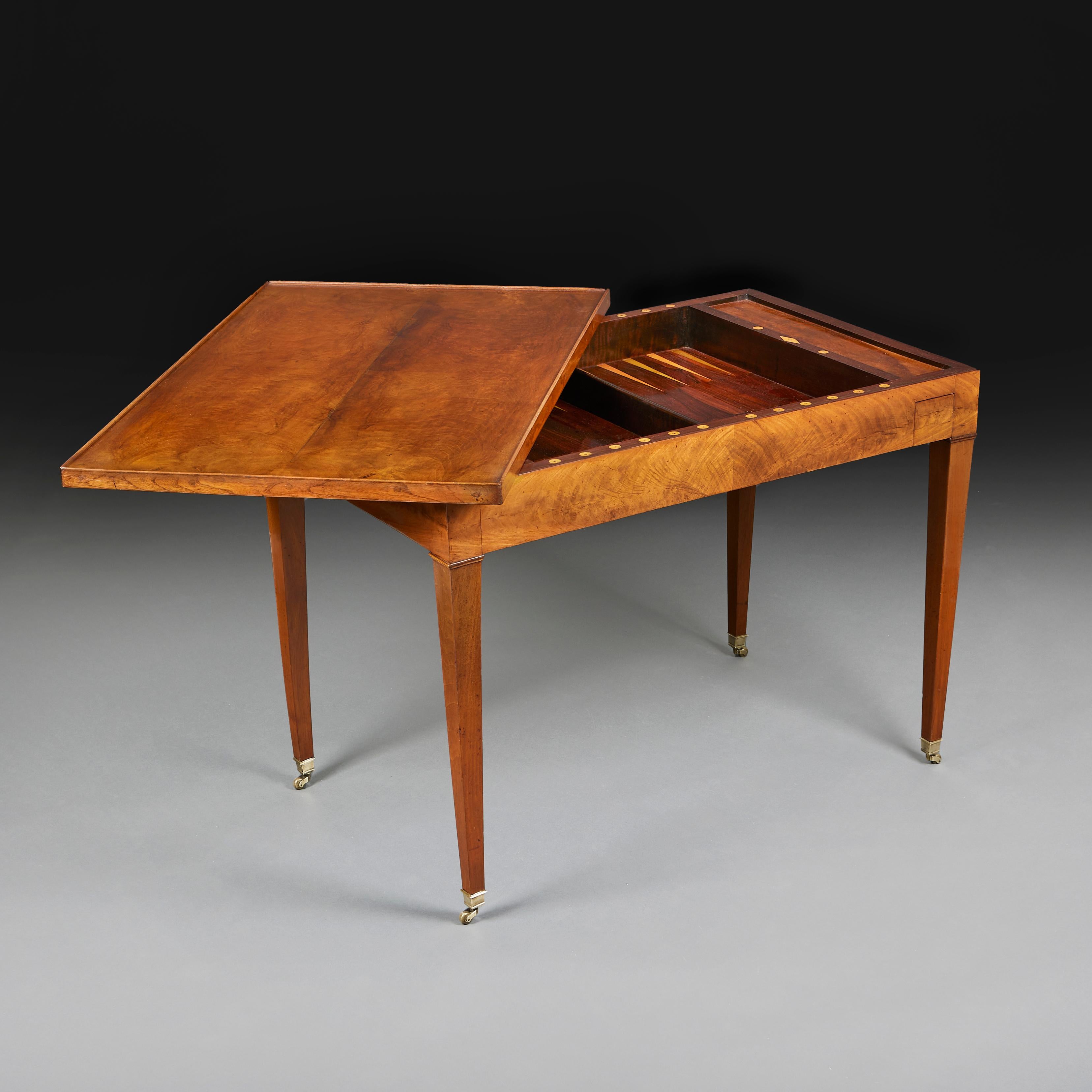 Fina mesa de backgammon de nogal de principios del siglo XIX, con superficie de juego insertada de madera de boj y madera de tulipán, con dos cajones opuestos para las fichas, tablero desmontable con batista en la parte inferior para las cartas,