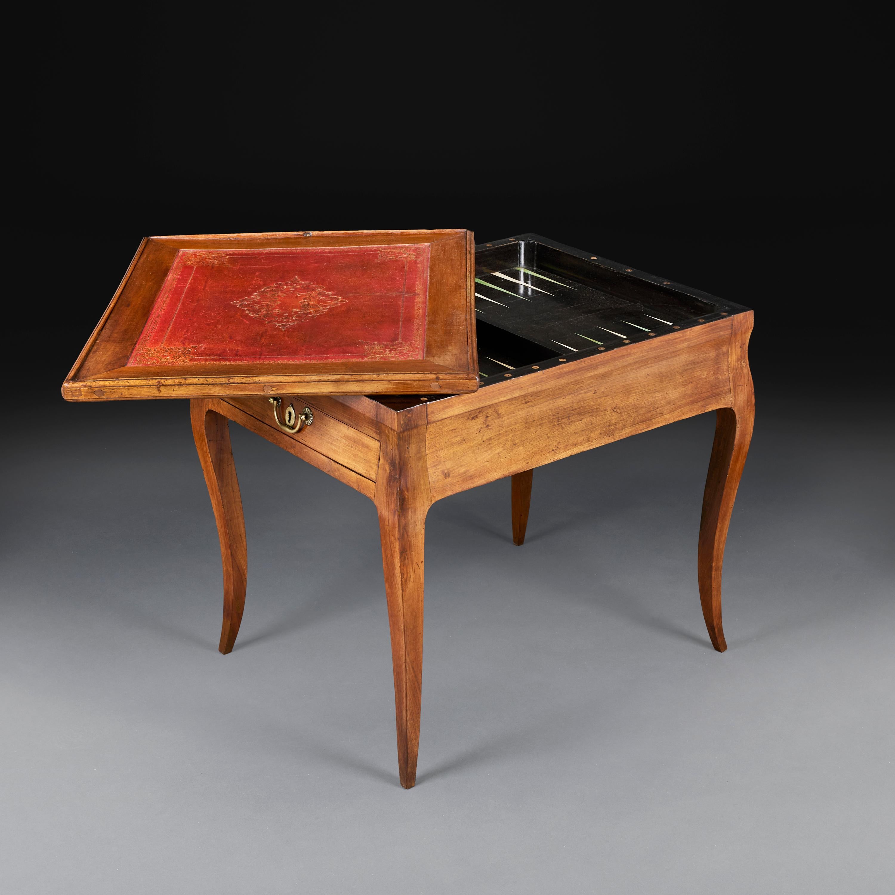 France, circa 1820

An early nineteenth century tric trac table with drawer to each end with brass handles, with ebonised backgammon playing surface, the with red leather to one side and baize to the other, all supported on cariole legs. 

Height