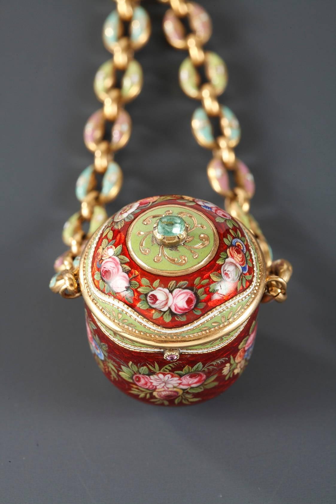 Antique gold and enamel vinaigrette suspended from two chains joined to a ring. The vinaigrette is decorated with multicolored bouquets of roses, and the interior grill serves to hold in place a piece of cotton or fabric that has been soaked in