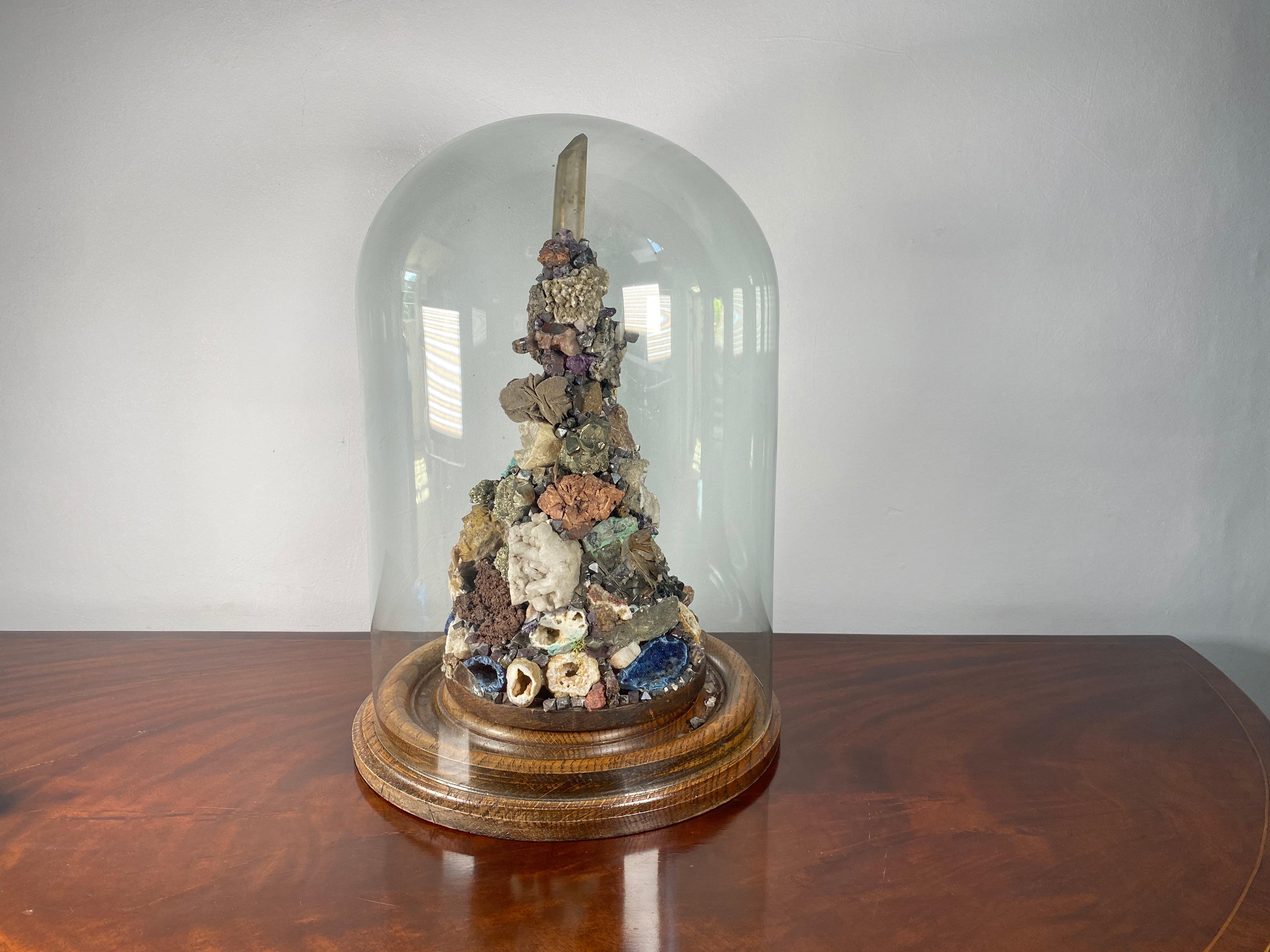 This incredible speciamn display has a vast assortment of various minerals all displayed proudly under a glass dome.