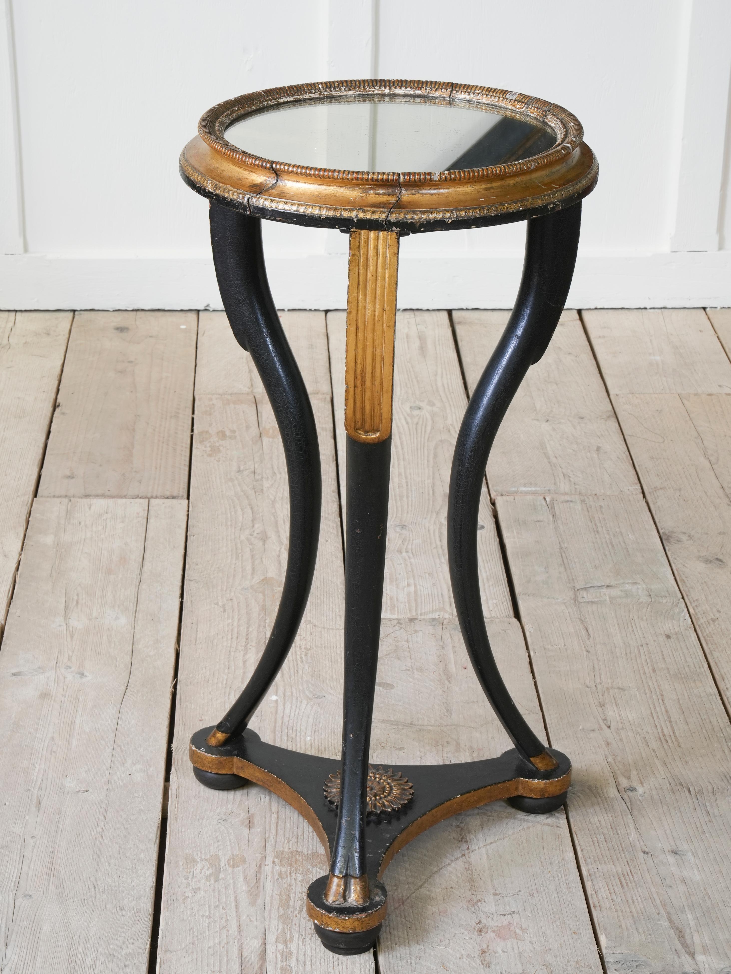 The tri-form base with rossette below splayed legs with hoof foot, painted and gilt decorations, mirrored top.

French circa 1820.

H:80 W:40 D:40 CM

H:31.5 W:15.9 D:15.9 INCHES.