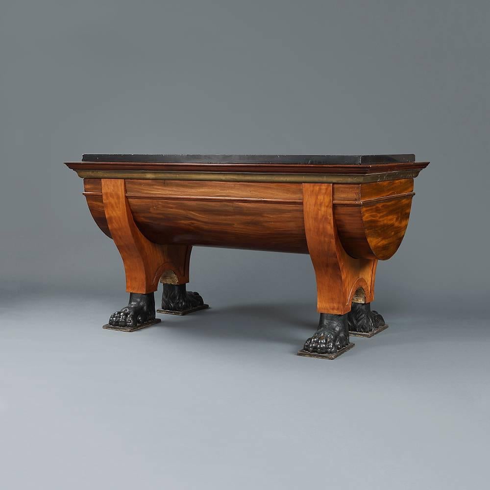 An early 19th century Northern European cherrywood, mahogany and oak centre table with rectangular inset Belgian black marble top over drum central section on downswept supported legs terminating in bronzes lion hairy paw feet on pads.
Possibly