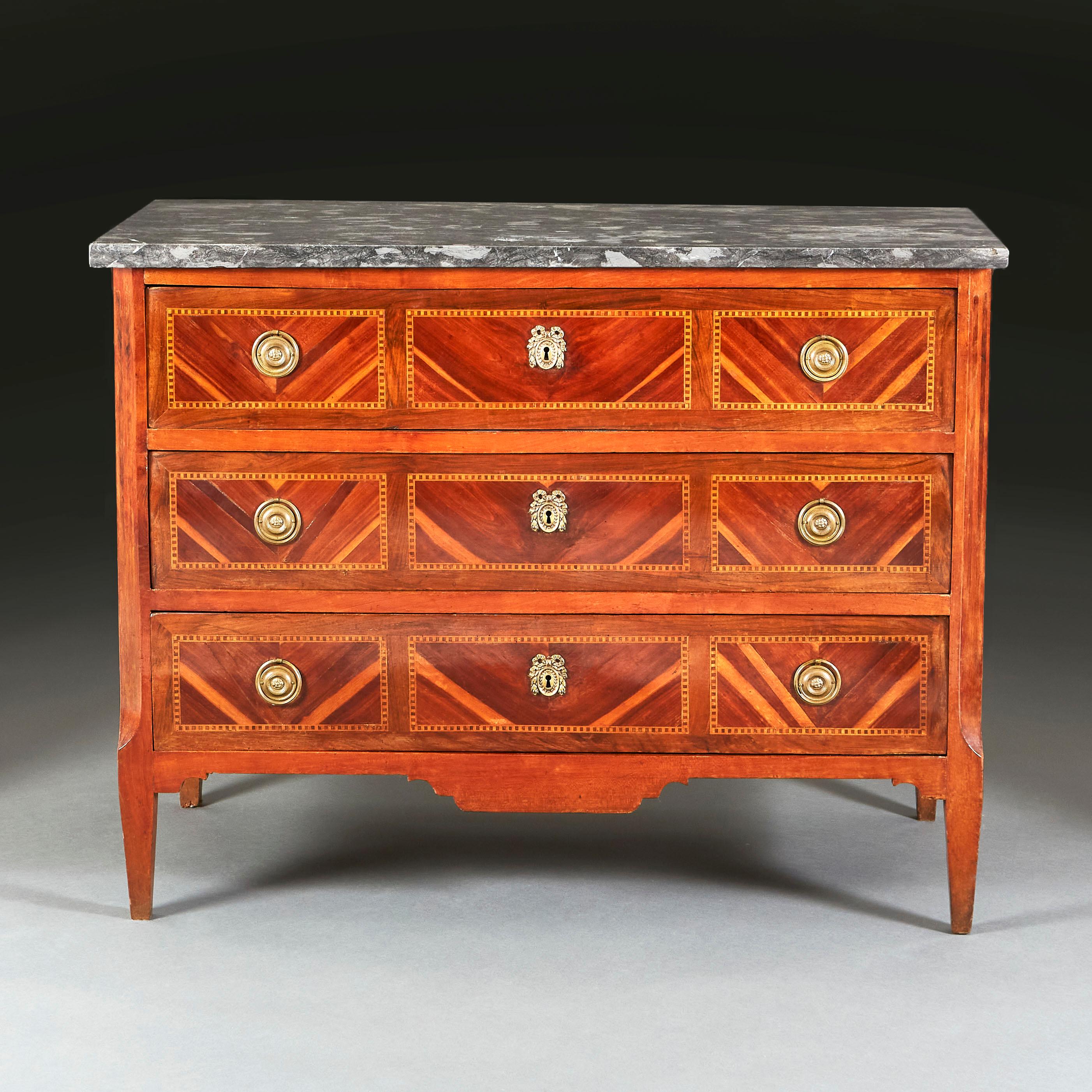 An early nineteenth century mahogany and kingwood parquetry commode, with grey marble top and with three drawers retaining the original handles and escutcheons, all supported on bracket feet.