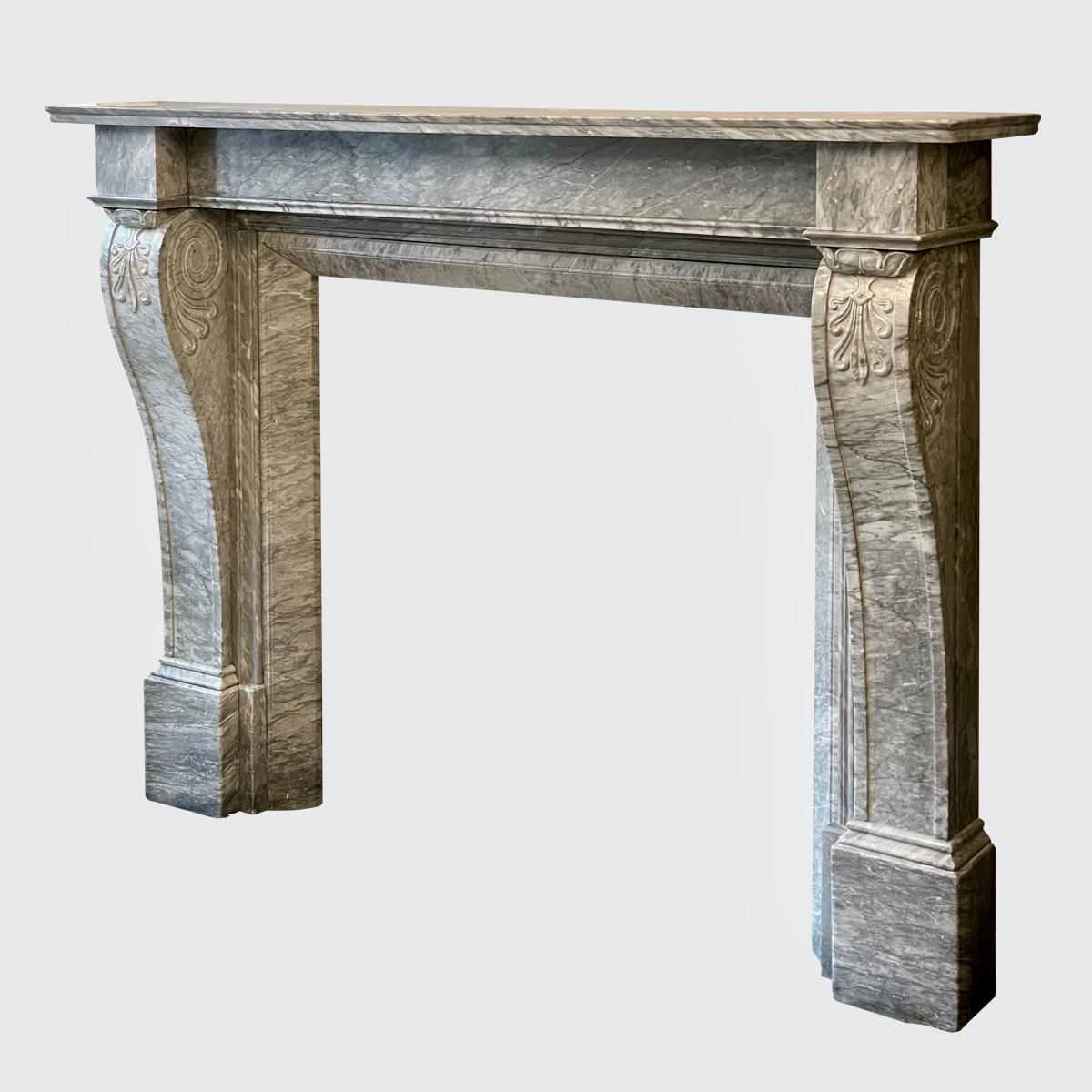 A well drawn and superb quality English Regency fireplace in Italian Bardiglio marble. The paneled console jambs with anthemion carving to front and scrolled anthemion carving to sides, supported on substantial foot blocks and capped with square end