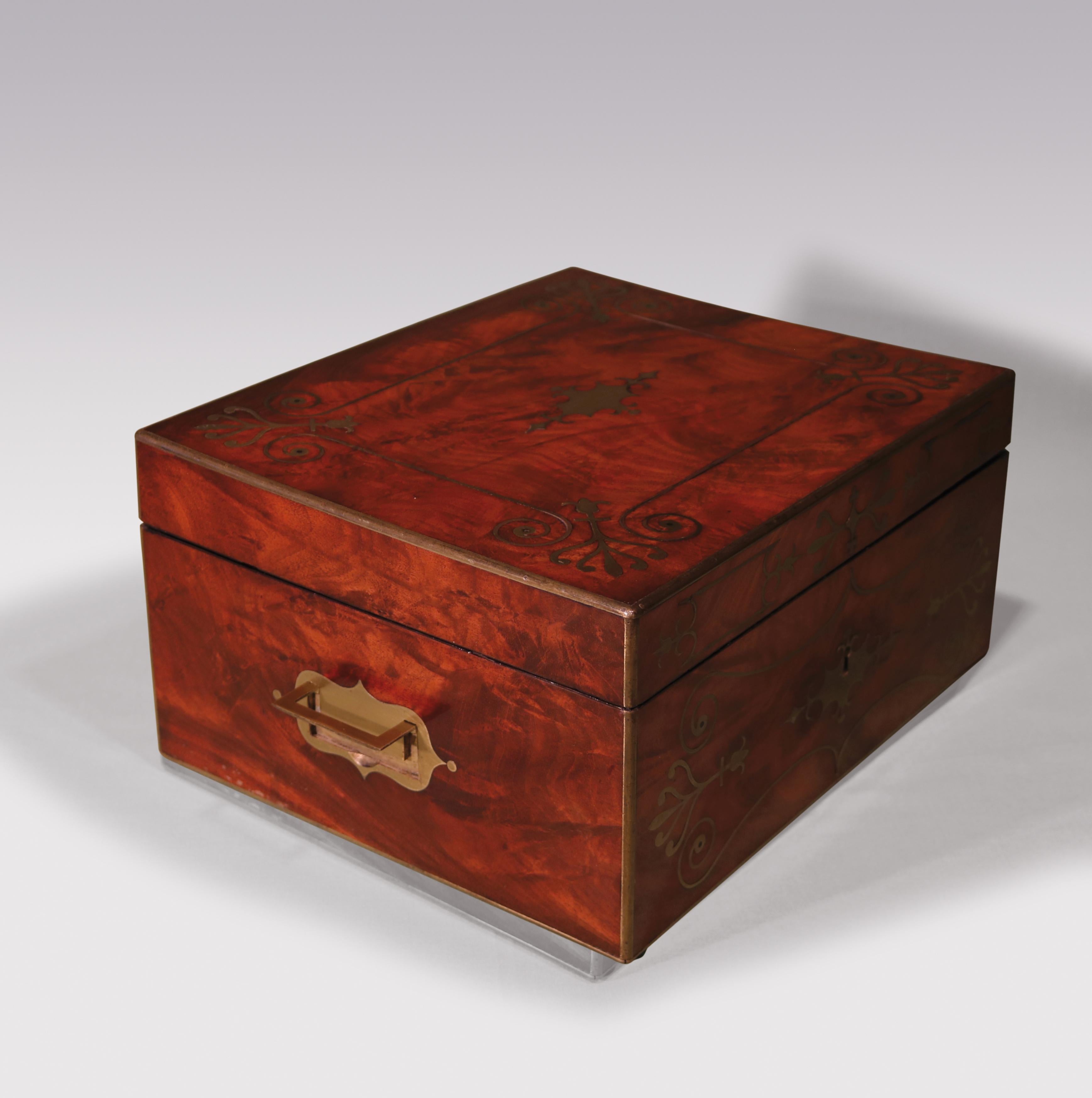 A fine quality early 19th century Regency period flame-figured mahogany stationary box with concealed carrying handles, intricately brass inlaid with scrolls, harebells & acanthus designs.