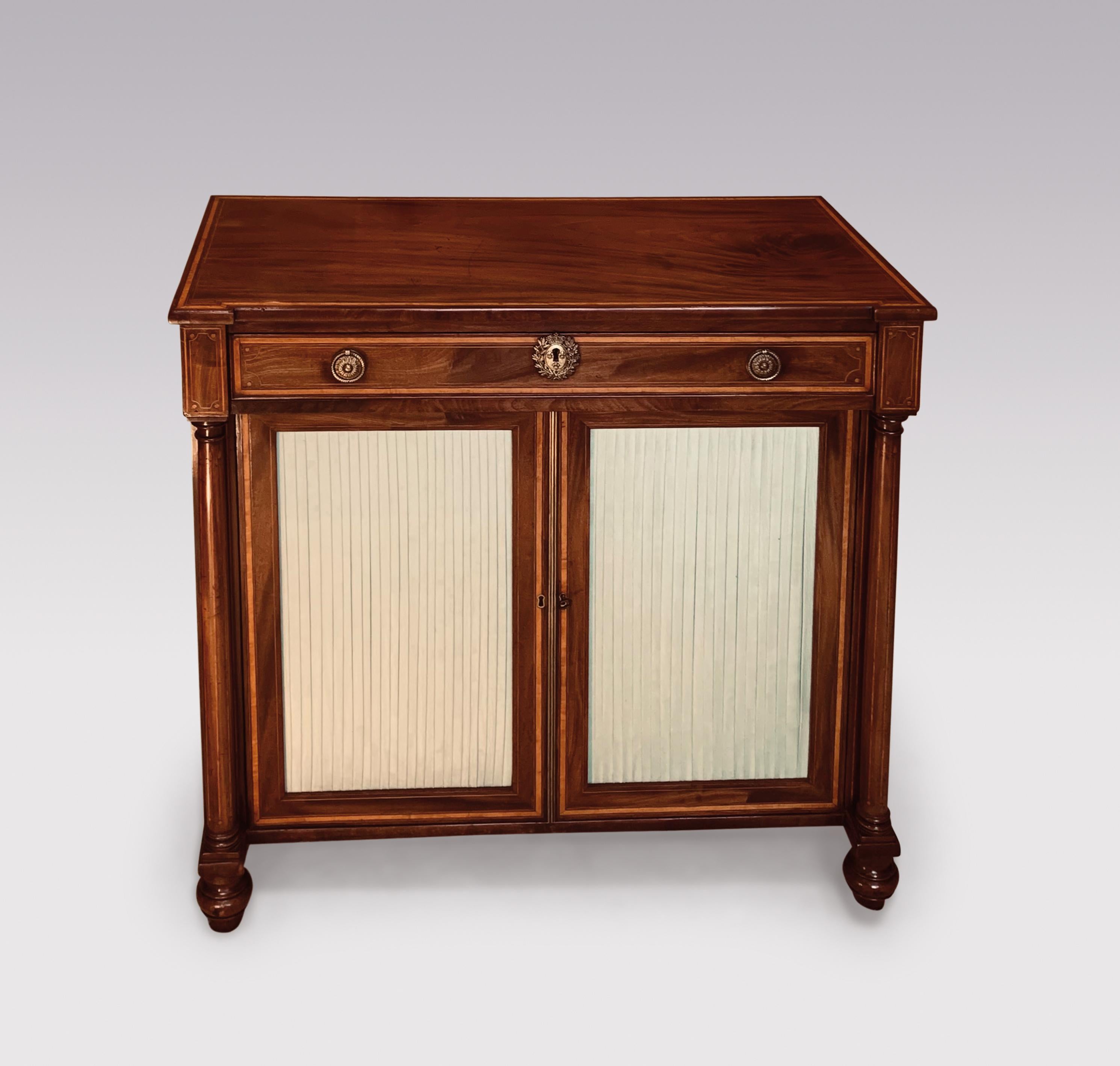 An early 19th Century Regency period figured mahogany two door cabinet, satinwood banded throughout having fieze drawer above pleated panelled doors flanked by satinwood line inlaid columns, supported on short turned legs.