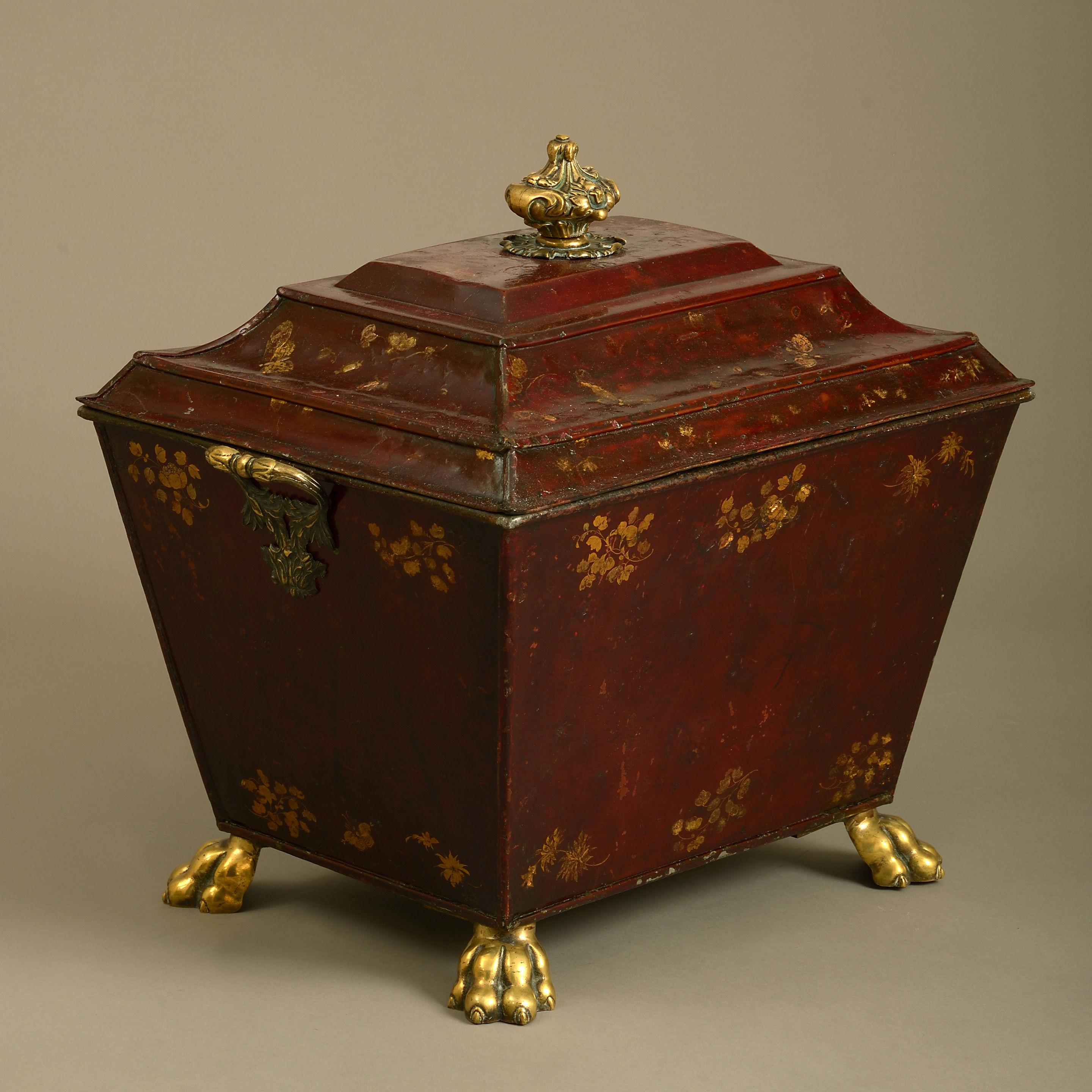A fine early 19th century Regency period tole coal bin decorated throughout with gilded butterflies, flowers and foliage upon a dark red ground, the lid having a finely cast knop, the body with carrying handles and lions paw feet of the same.