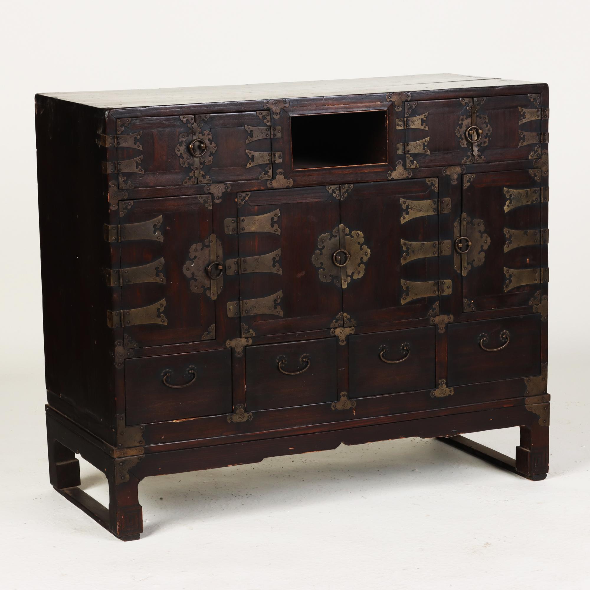 An early 19thCentury Korean chest with beautiful ornate brushed brass details and hinges.
 Elmwood.
 Chest has two small doors flanking one larger front door which open to reveal storage and three drawers along the bottom part and 2 along top.