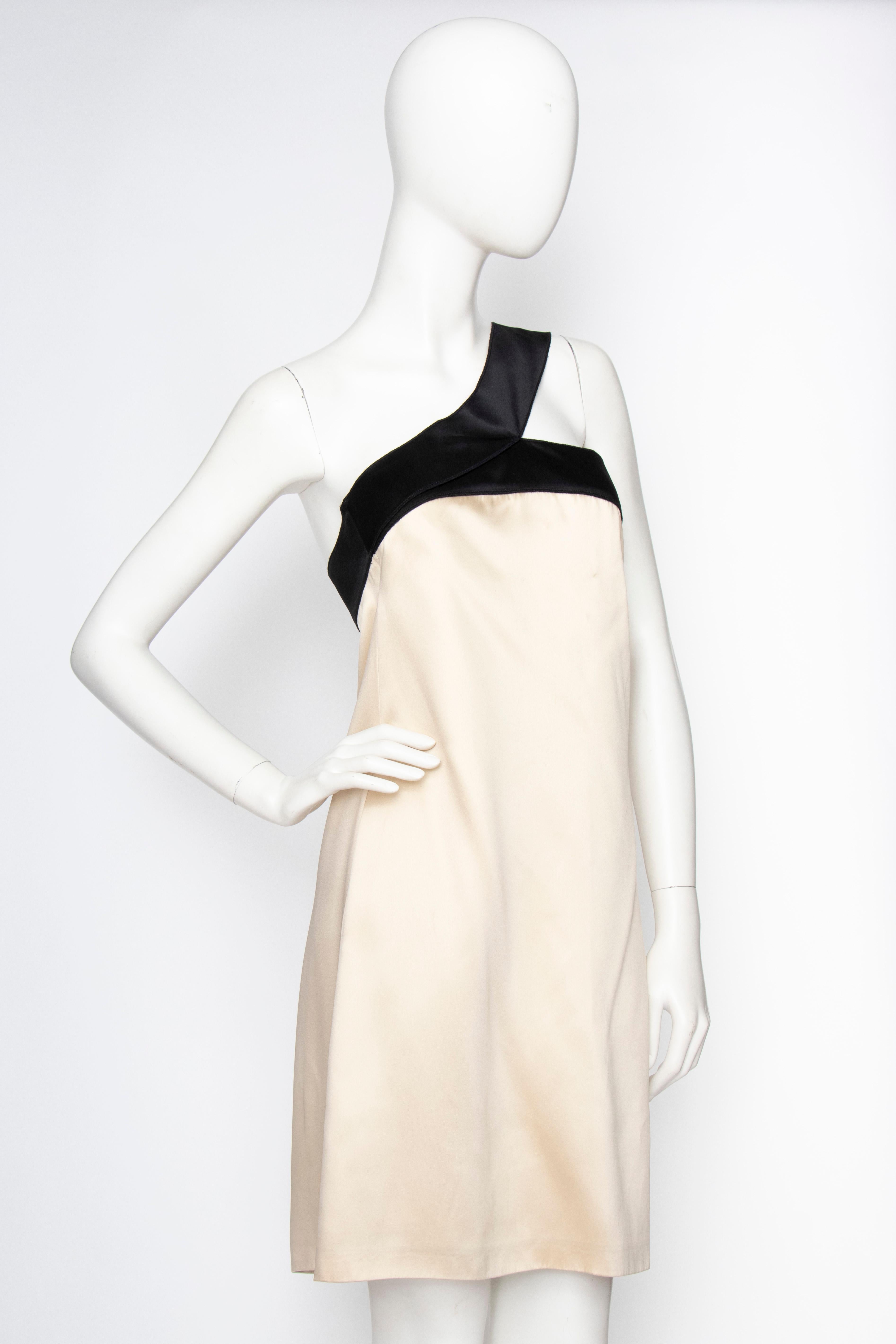 An early 2000s D&G by Dolce & Gabbana ivory satin column cocktail dress with contrasting black trim and asymmetrical shoulder strap. The dress is lined in silk and has invisible side pockets. 

The size of the dress corresponds to a modern size