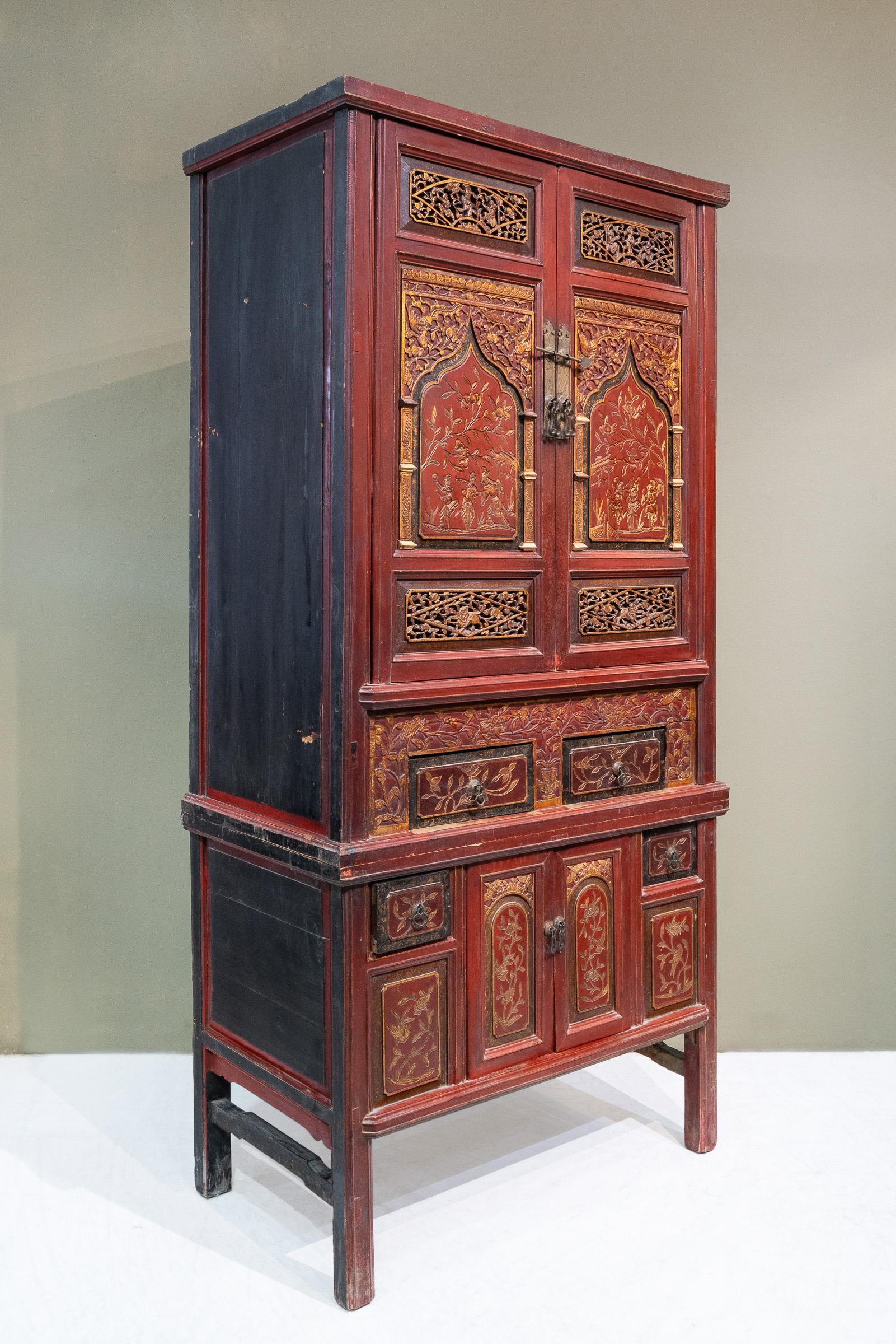 An early 20th century 2-tier carved cabinet from Fujian province, specifically Quanzhou city, China. There is nice combination of through and relief carvings throughout this cabinet, and it is decorated with many auspicious symbols like the phoenix,
