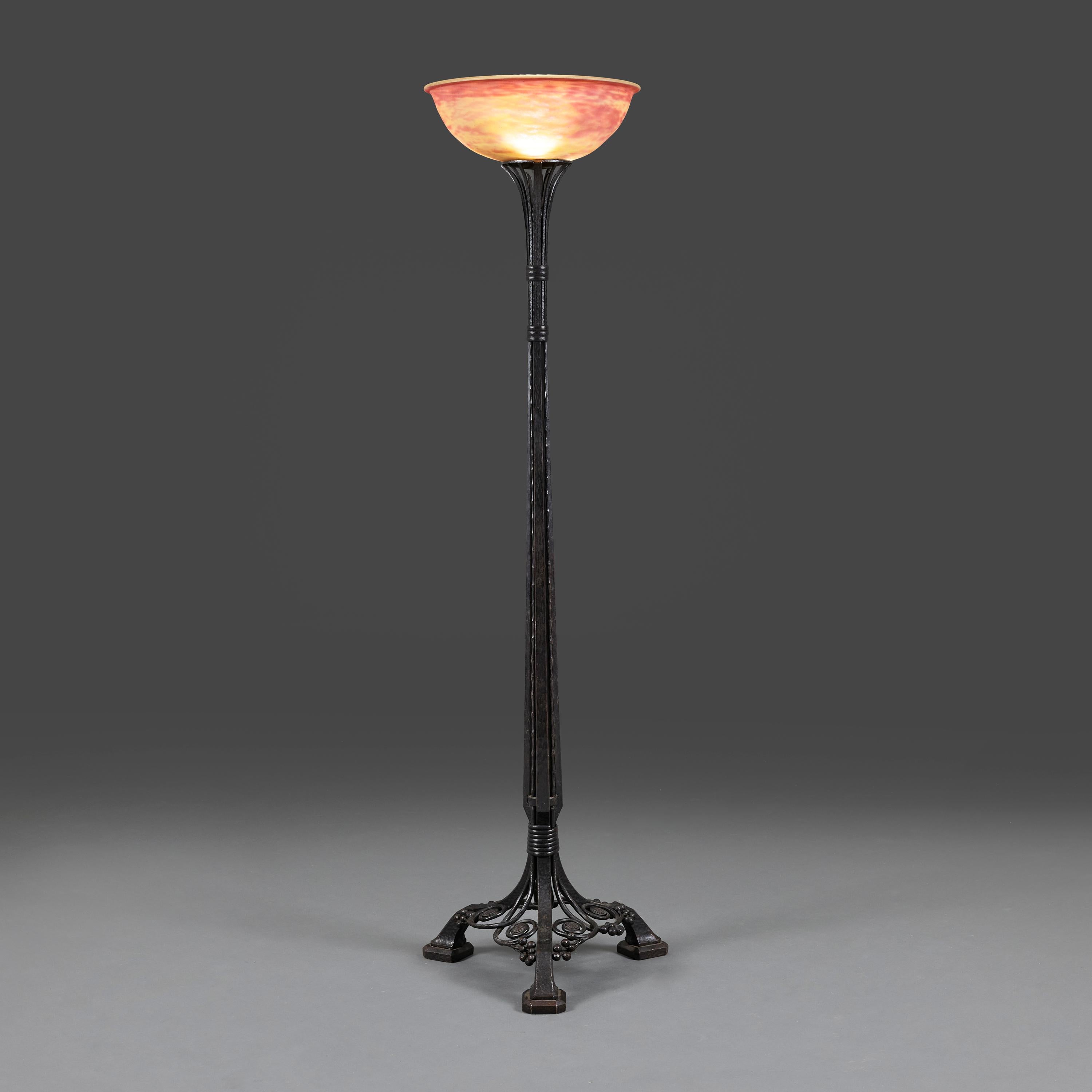 Francia, circa 1930.

Eccezionale lampada da terra Art Deco con stelo in ferro battuto nero che termina in una base a treppiede con volute e bacche, firmata da Charles Piguet, che sostiene un paralume in vetro rosso pate de verre firmato Daum