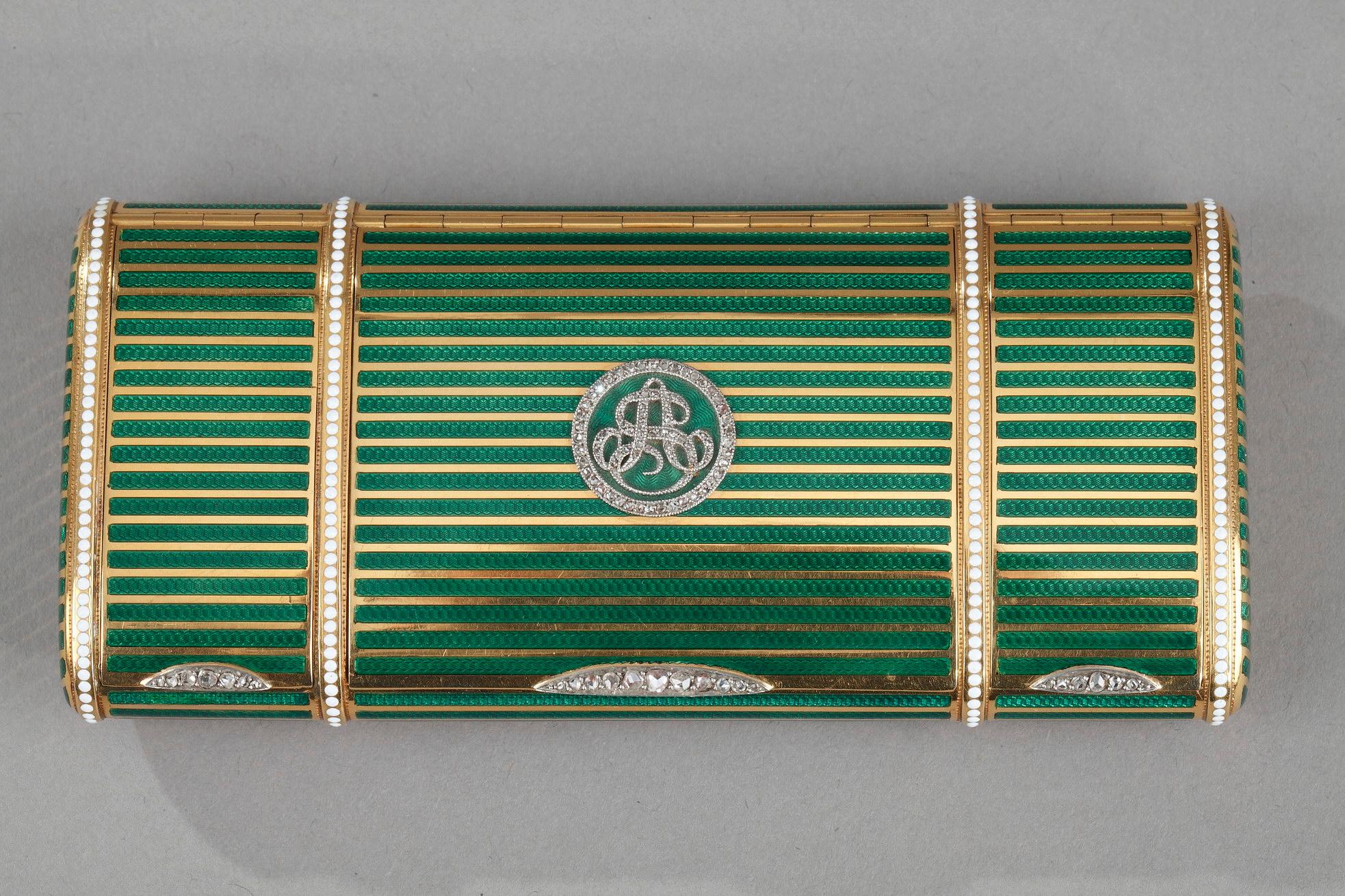 A rectangular vanity case or box, with bi-color gold and green translucent enamel. The decoration presents an alternation of gold bands and enamel bands of translucent green color revealing a guilloché. The box reveals three compartments probably to