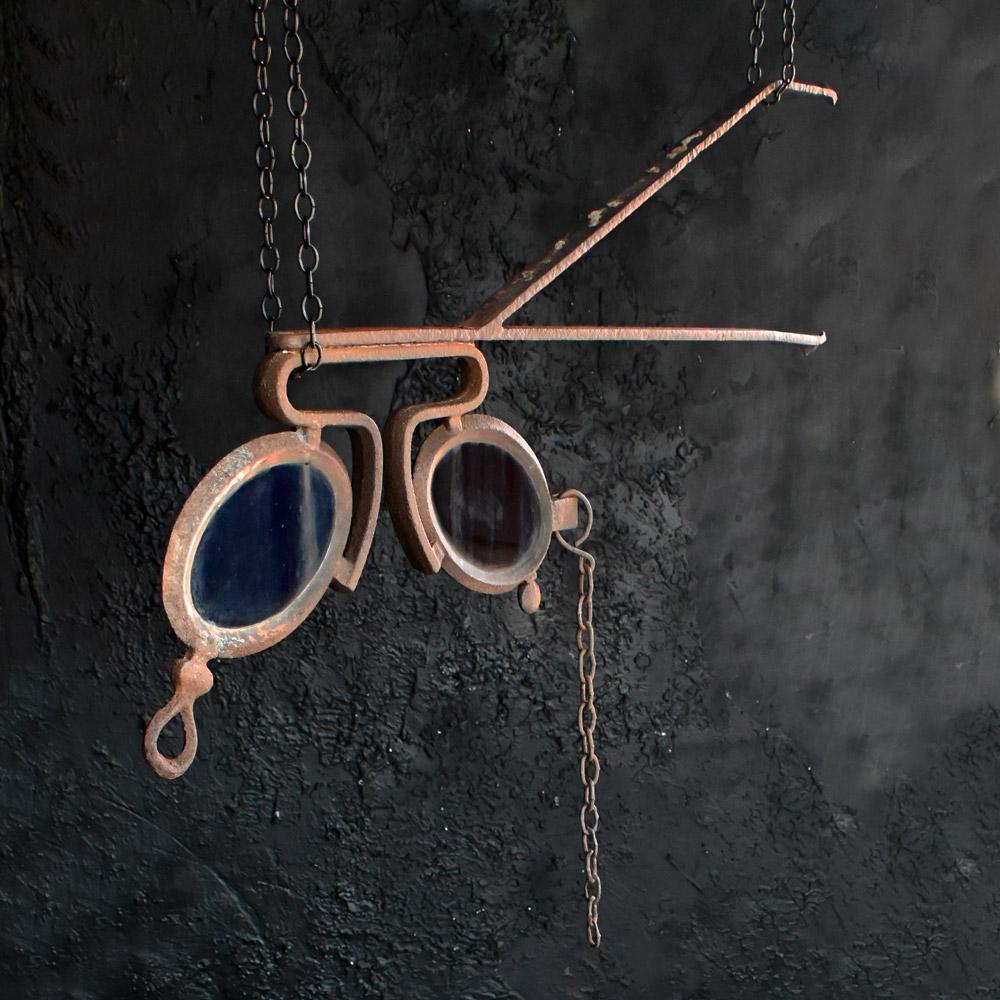 An early 20th century cast metal and glass opticians trade sign.
An early 20th century cast metal and glass opticians trade sign, in the form of a quirky pair of spectacles. Made from hand forged cast metal with red and blue glass lenses. A highly