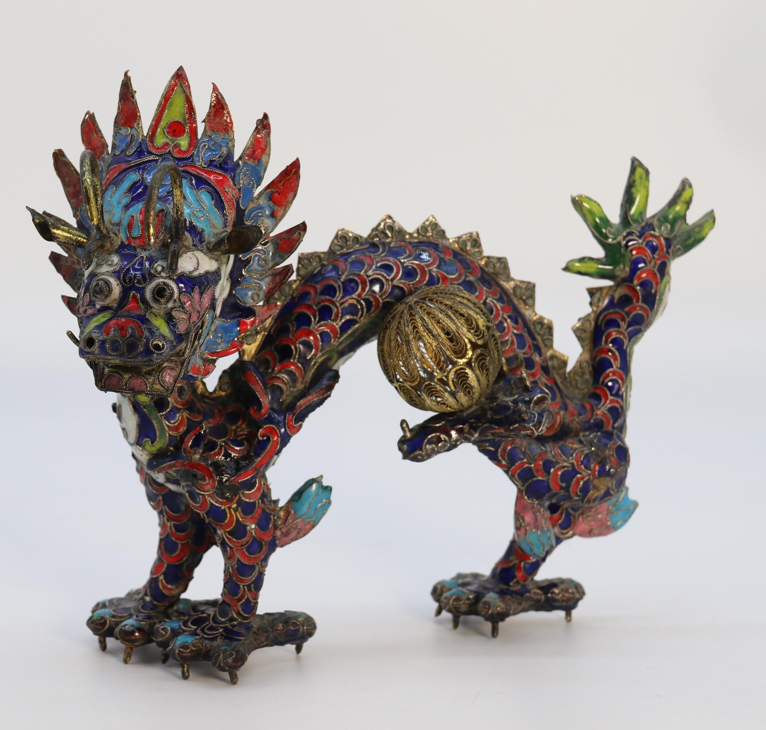 An early 20th century Chinese decorative cloisonne sculpture of a five clawed dragon gripping a ball.

This bright and unusual dragon is a Chinese work of art and dates to circa 1930. It has been hand made from thin beaten copper forming the hollow